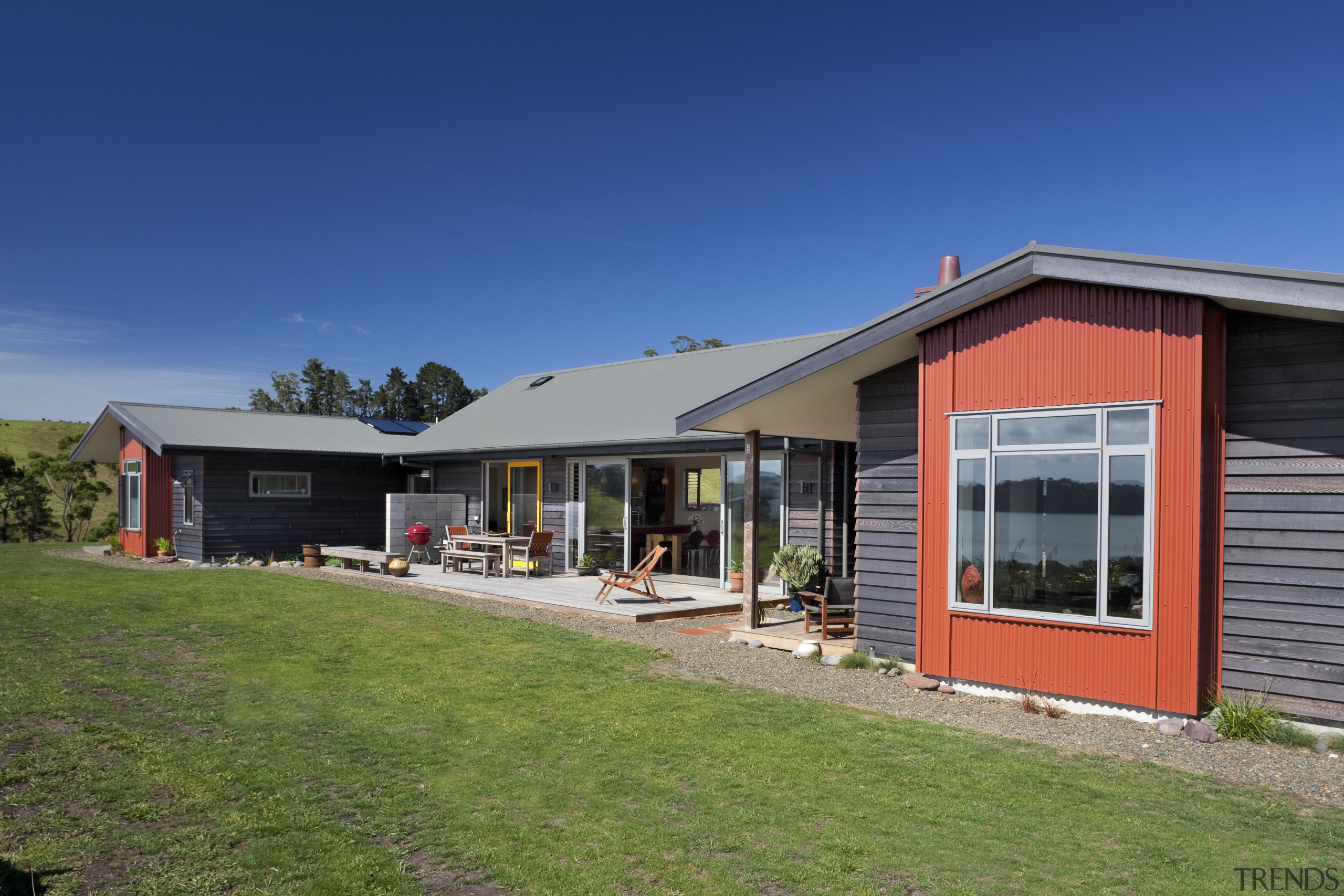 View of exterior with red wall and patio cottage, estate, facade, farmhouse, home, house, property, real estate, residential area, roof, siding, sky, window, blue