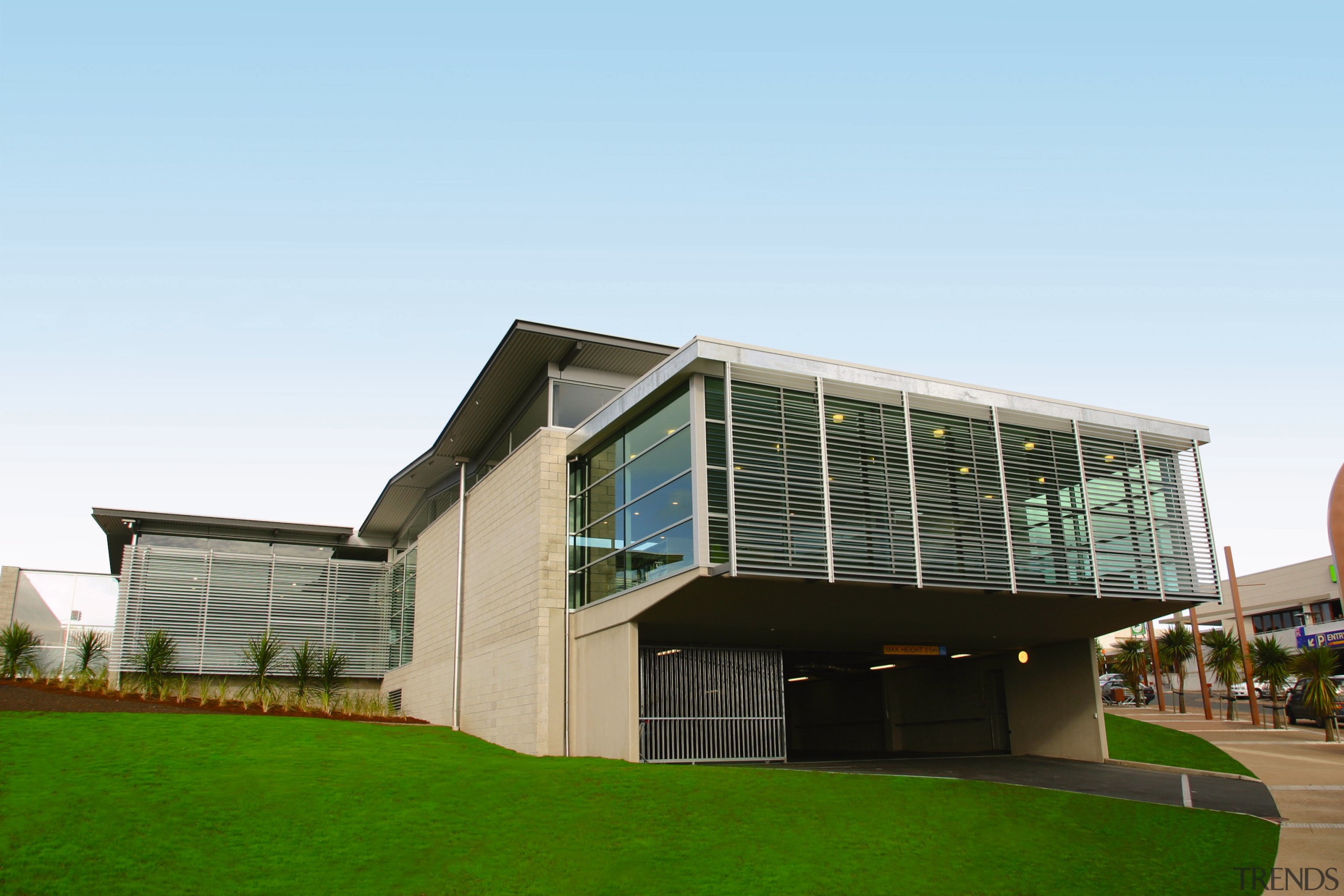 Exterior view of building featuring brick cladding, windows, architecture, building, corporate headquarters, elevation, facade, grass, home, house, mixed use, real estate, residential area, white