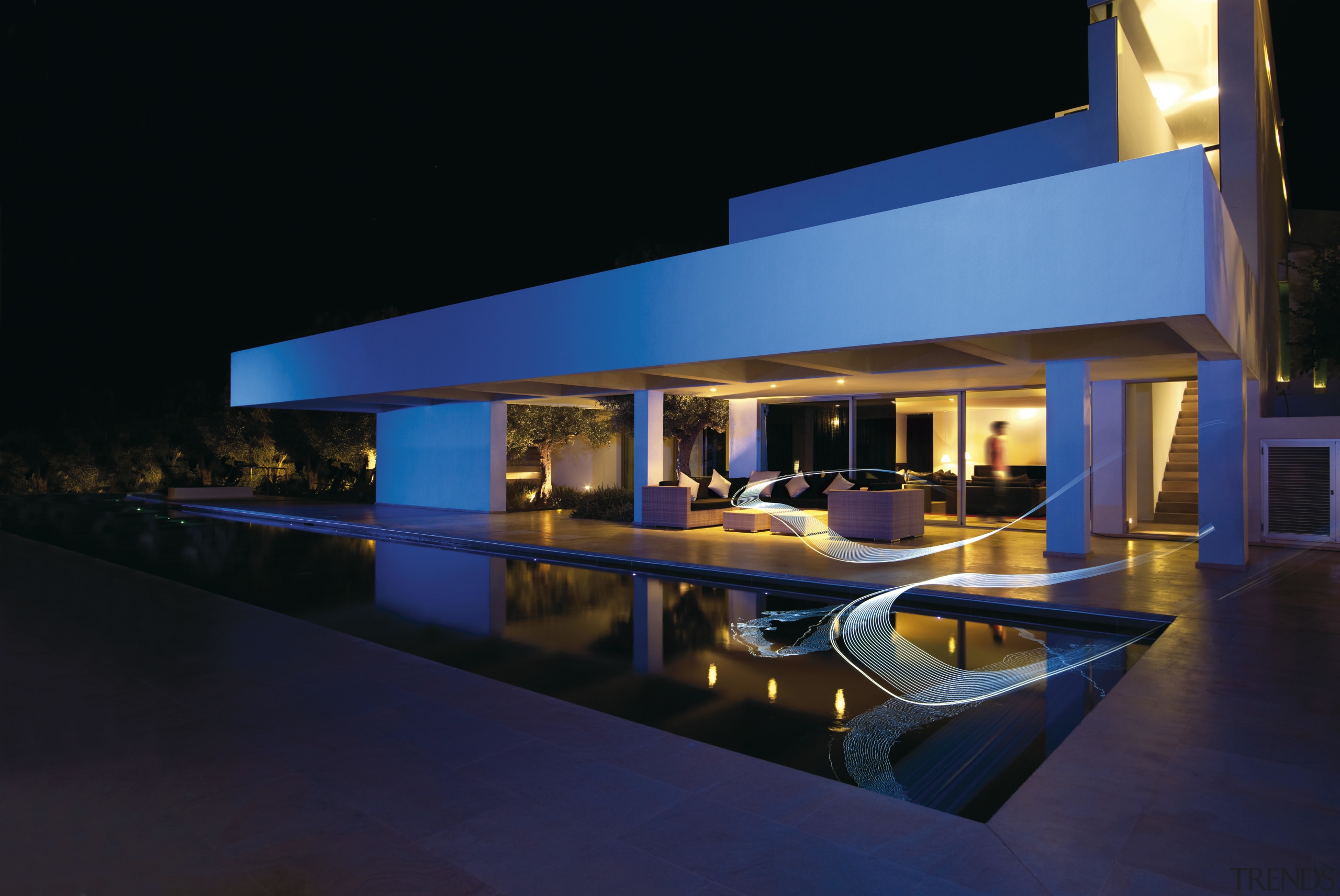 Exterior night shot of modern, white home with architecture, estate, home, house, lighting, property, real estate, reflection, swimming pool, water, black, blue