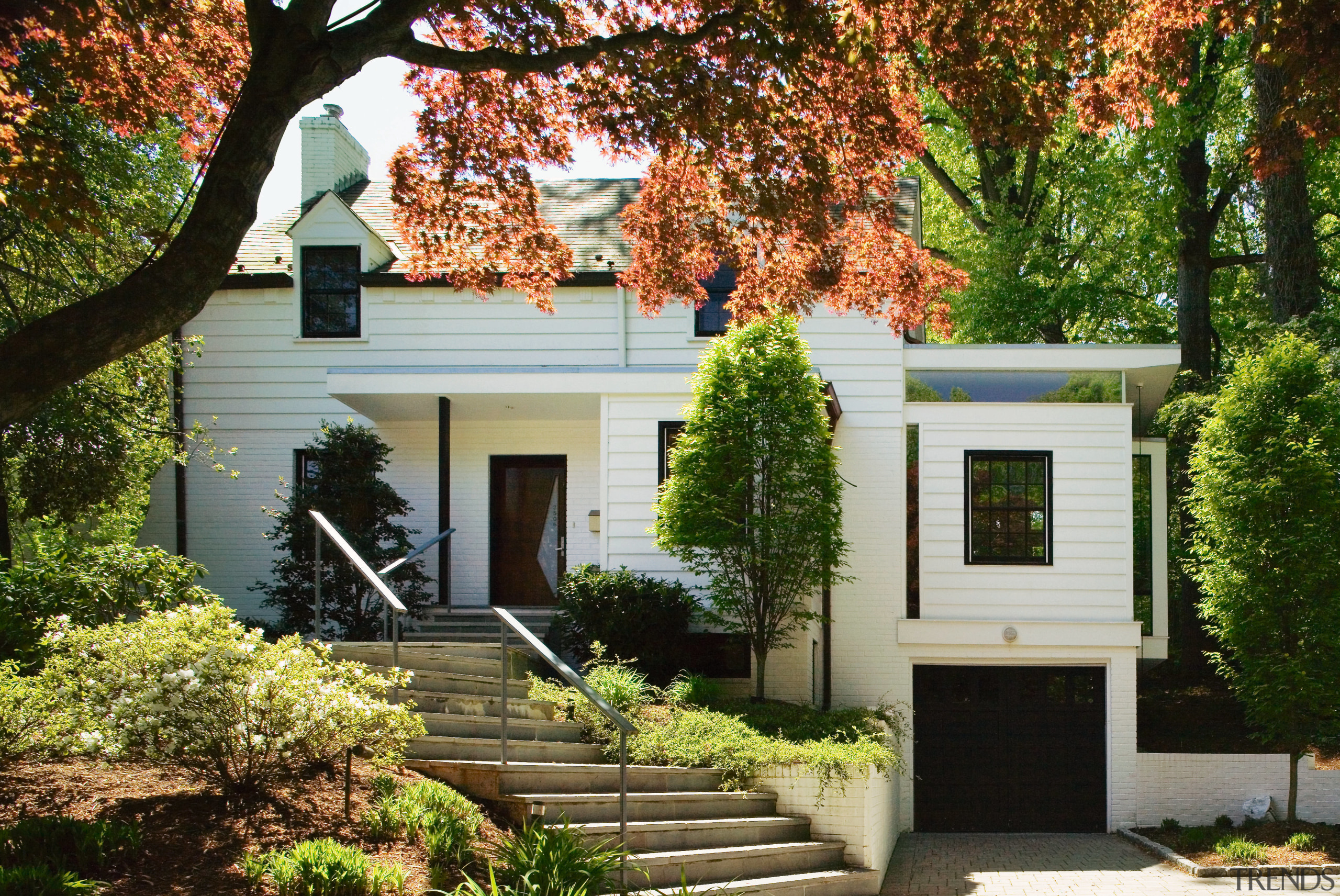 An exterior view of the entrance way to cottage, estate, facade, home, house, property, real estate, residential area, siding, tree, window, brown