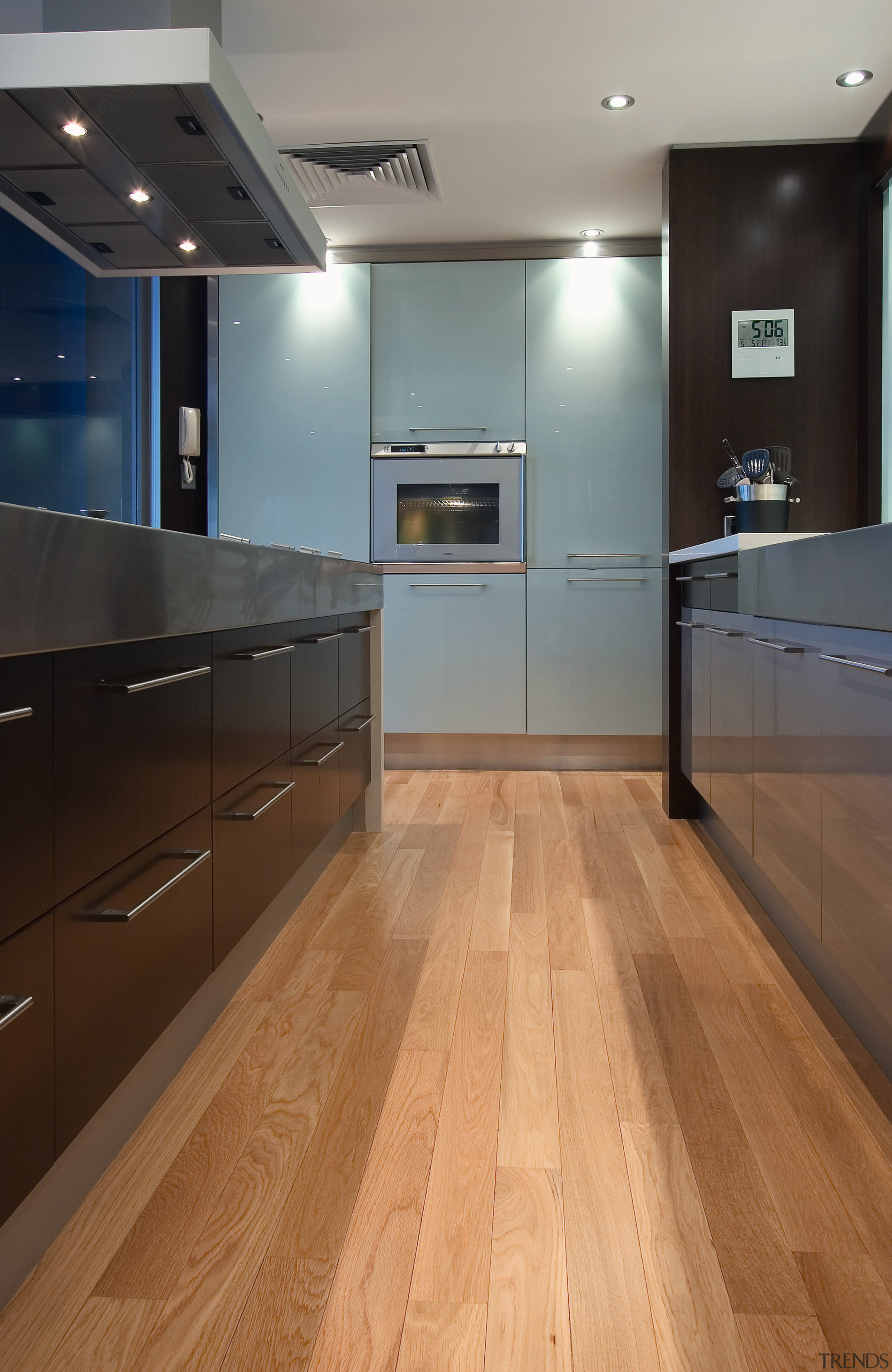 view of the kitchen featuring darkwood veneer wall, cabinetry, countertop, floor, flooring, hardwood, interior design, kitchen, laminate flooring, wood, wood flooring, gray, black