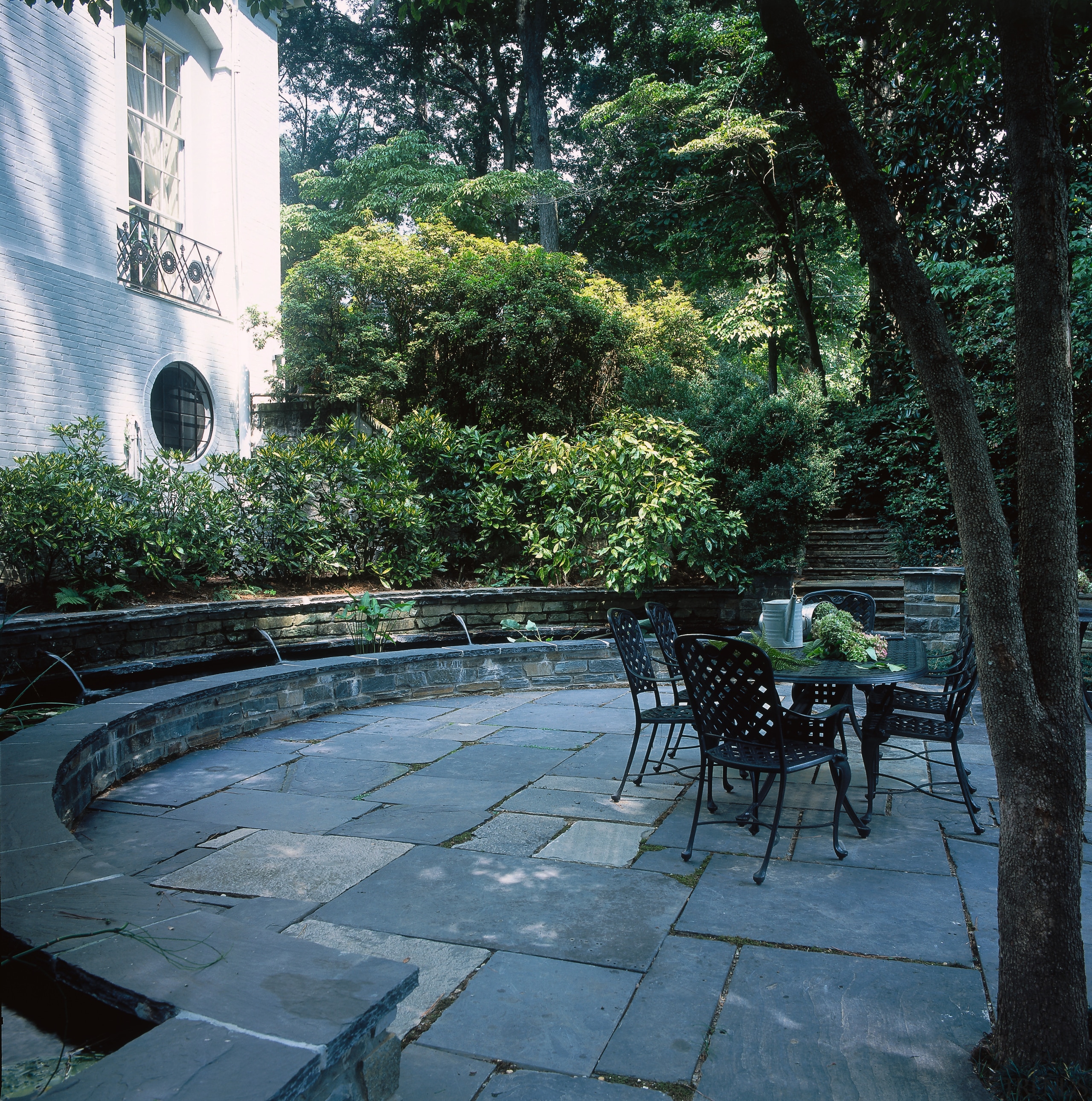 View of the patio area, tiled concrete ground, architecture, backyard, courtyard, garden, landscape, landscaping, outdoor structure, patio, plant, tree, walkway, yard, black, teal