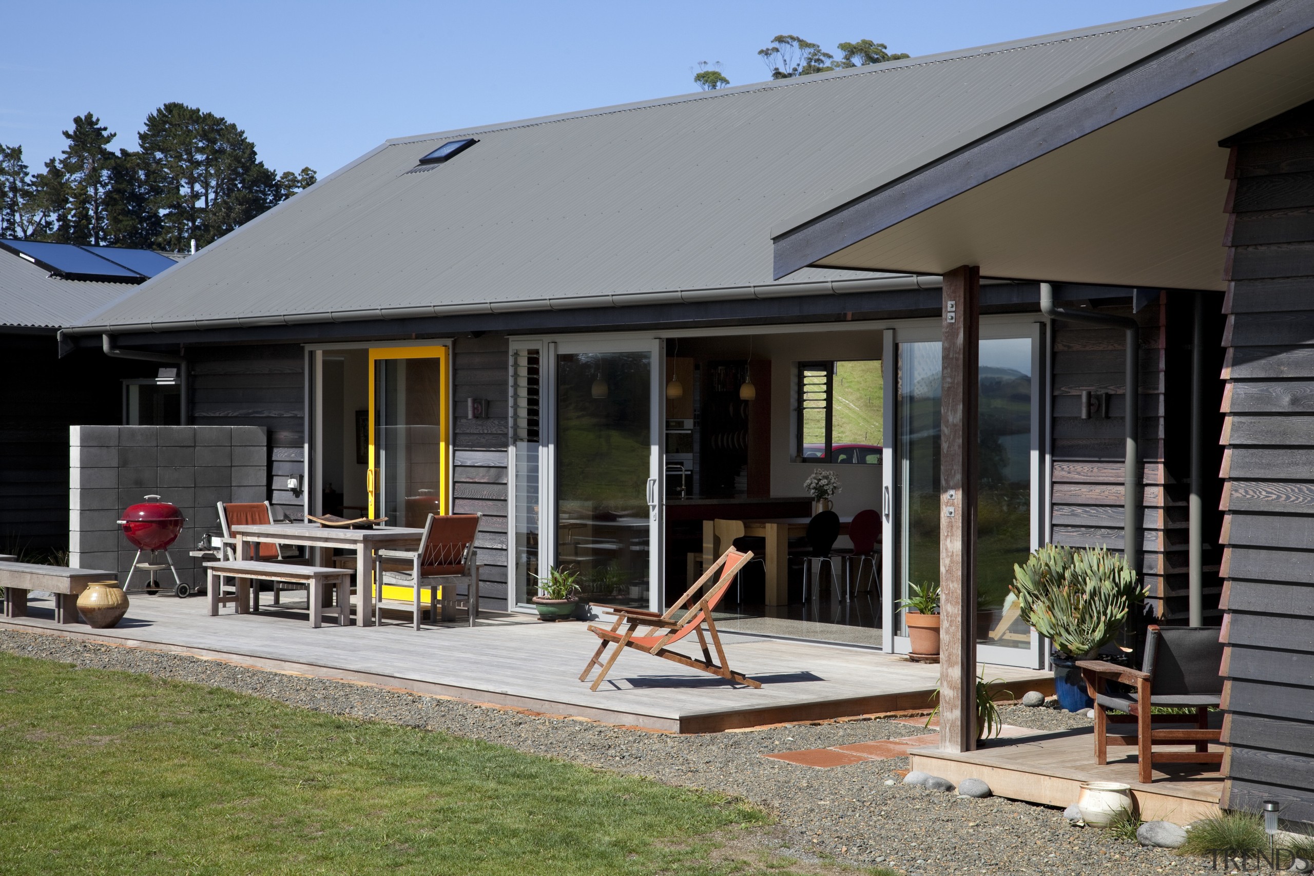 View of exterior with patio and yellow window backyard, home, house, outdoor structure, porch, real estate, siding, window, gray, black