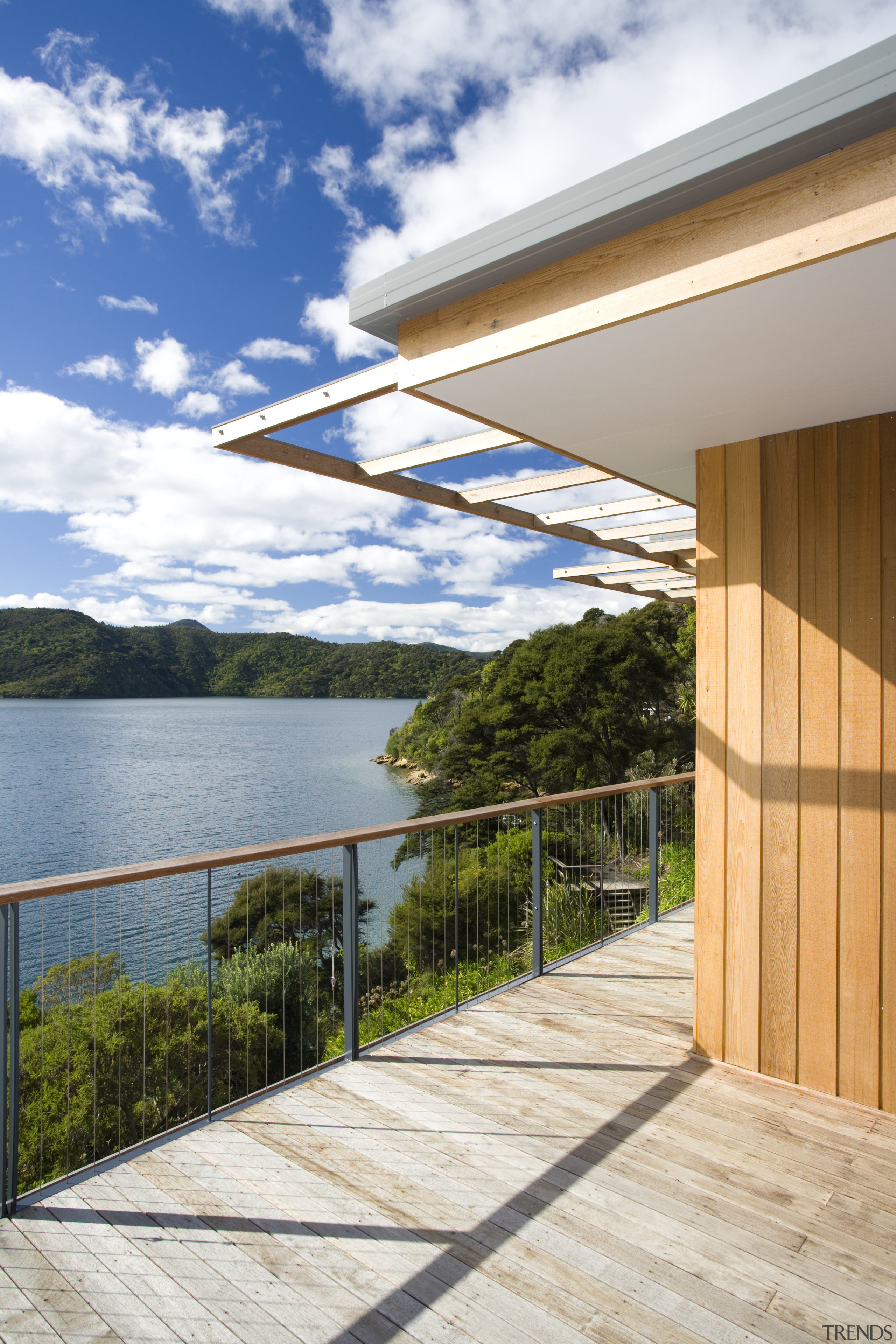 View of deck and side of house with architecture, condominium, estate, home, house, outdoor structure, property, real estate, sky, white