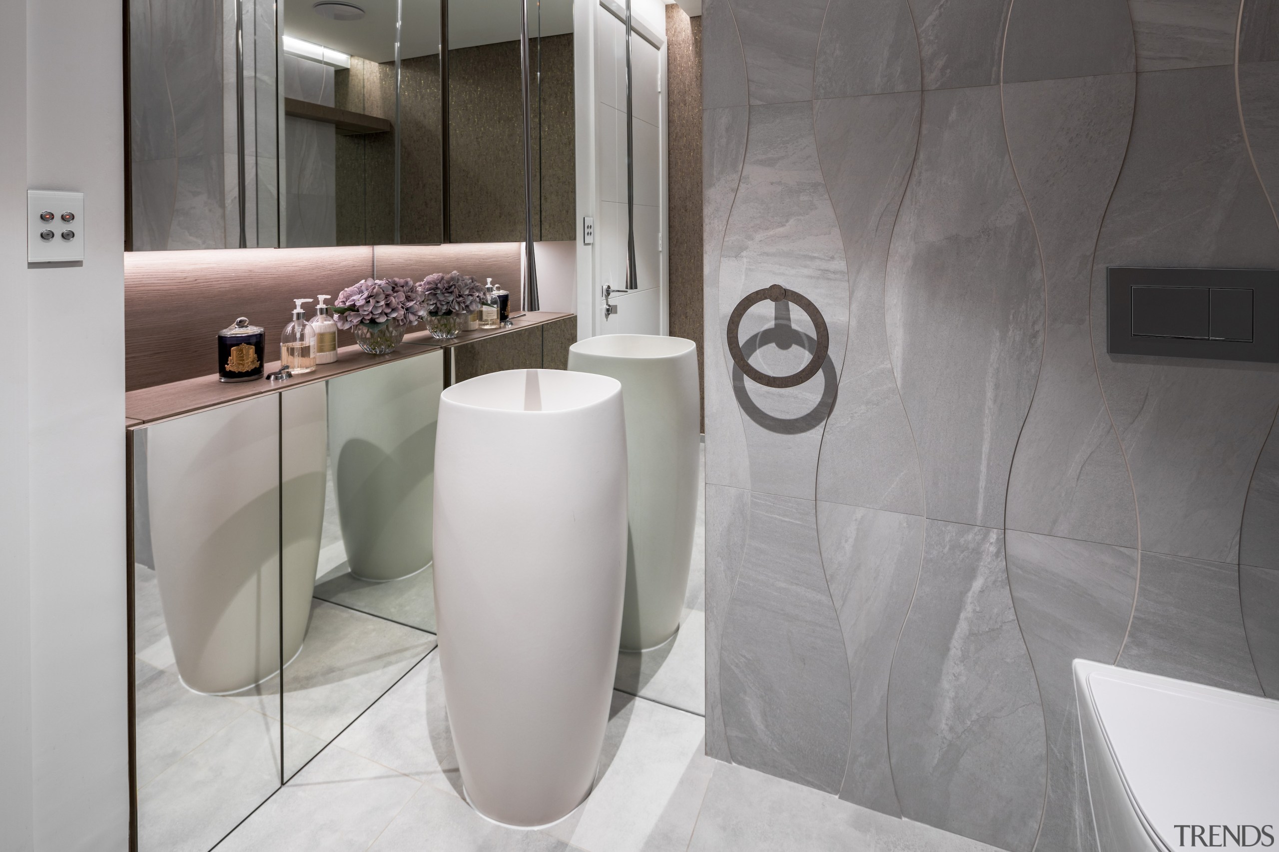 Bathroom with sculptural standing basin and curvaceous tile 