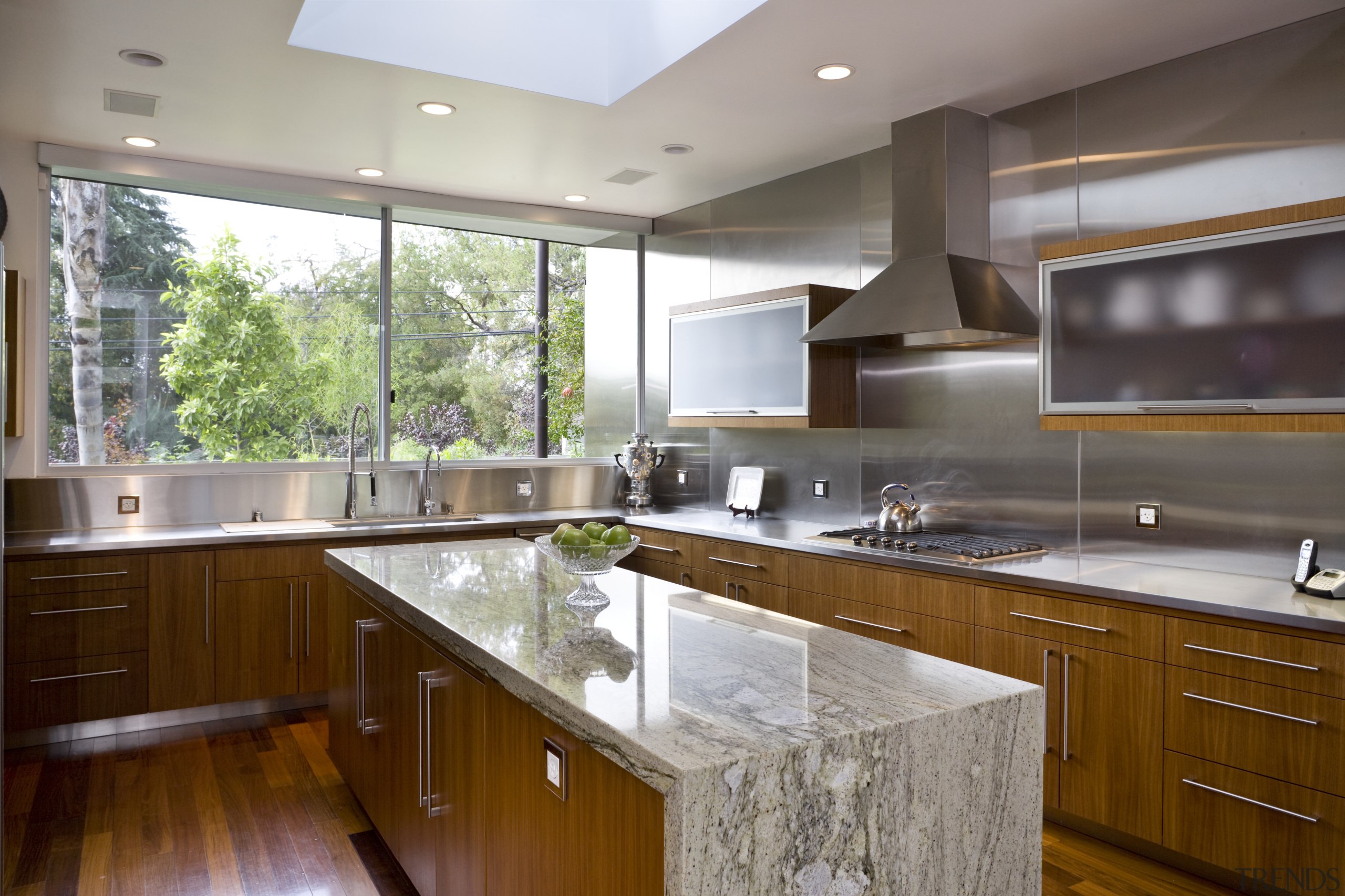 View of the kitchen featuring kitchen appliances, stainless cabinetry, countertop, cuisine classique, interior design, kitchen, real estate, room, gray, brown