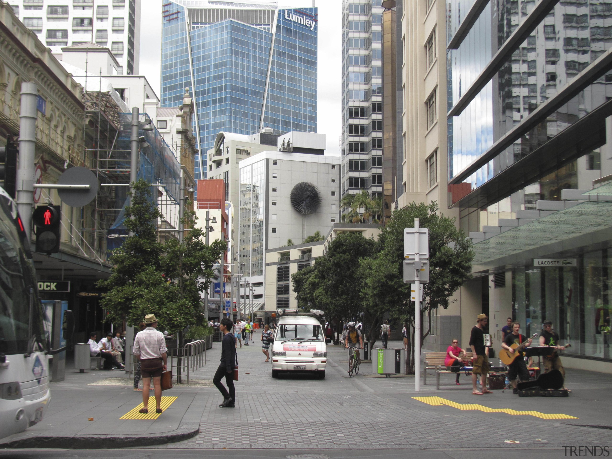 People-friendly streetscapes are revitalising our cities, as the building, car, city, condominium, daytime, downtown, infrastructure, lane, metropolis, metropolitan area, mixed use, neighbourhood, pedestrian, pedestrian crossing, residential area, road, skyscraper, street, tower block, town, traffic light, transport, tree, urban area, vehicle, gray, black