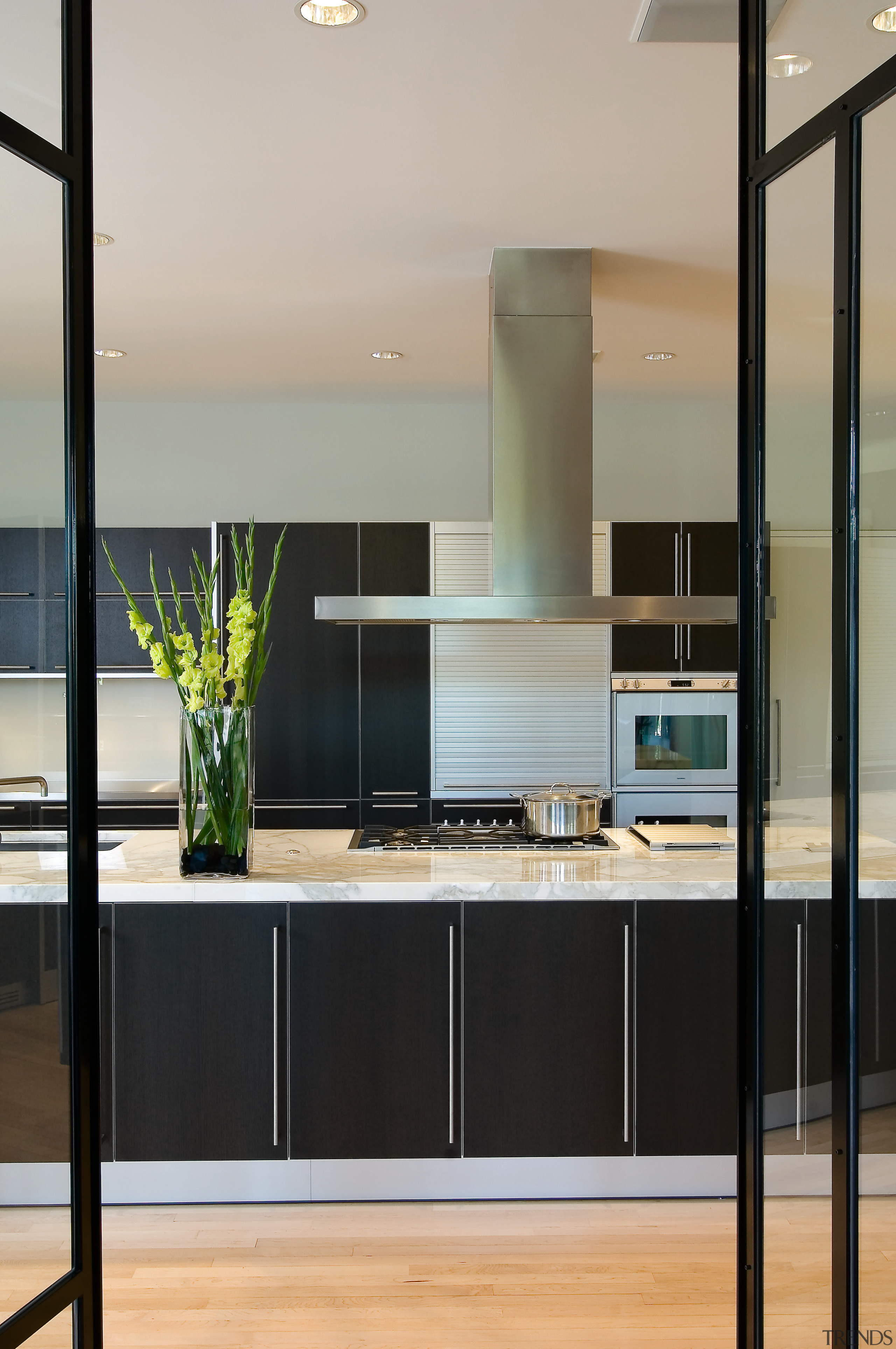 A view of this kitchen featuring maple flooring, cabinetry, countertop, interior design, kitchen, gray, black