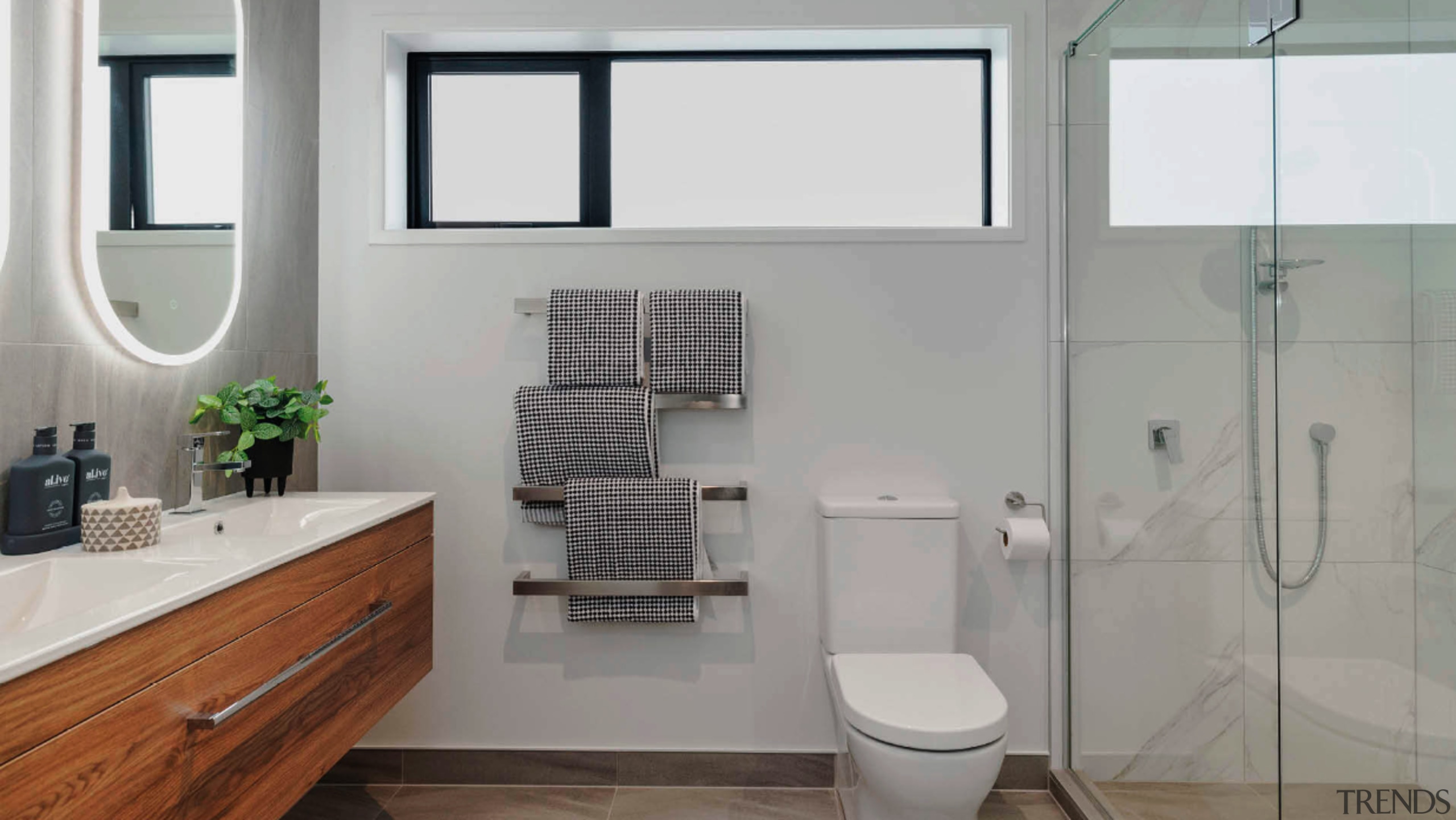 A wood-look vanity and clear glass shower stall 