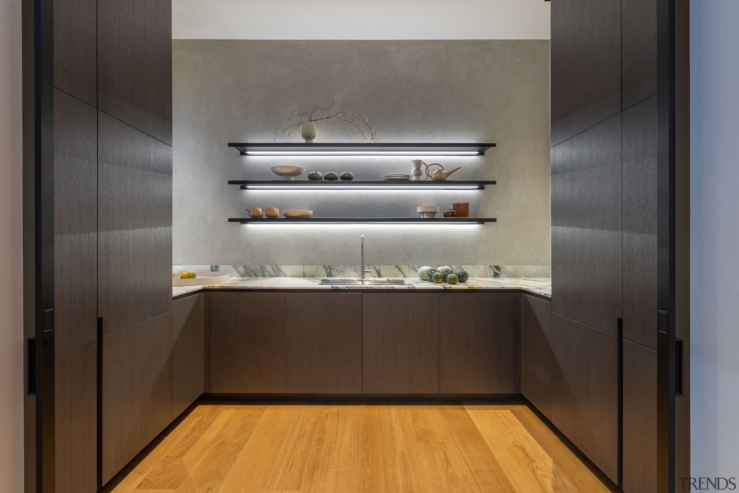 Underlit open shelving greets entry into the large 