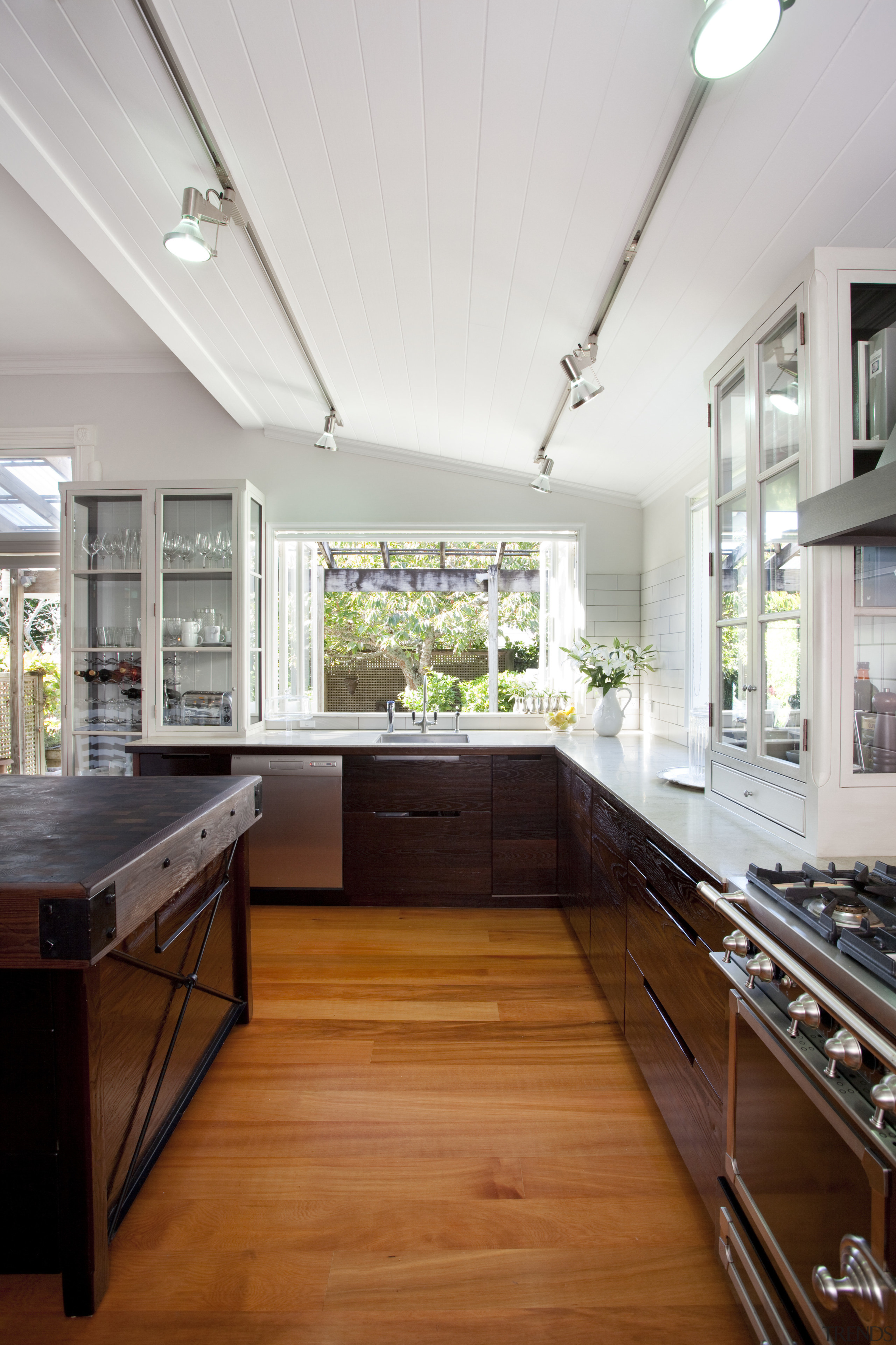 wooden floors and butcher's block island. dark cabinetry cabinetry, ceiling, countertop, cuisine classique, daylighting, hardwood, interior design, kitchen, room, wood, wood flooring, white