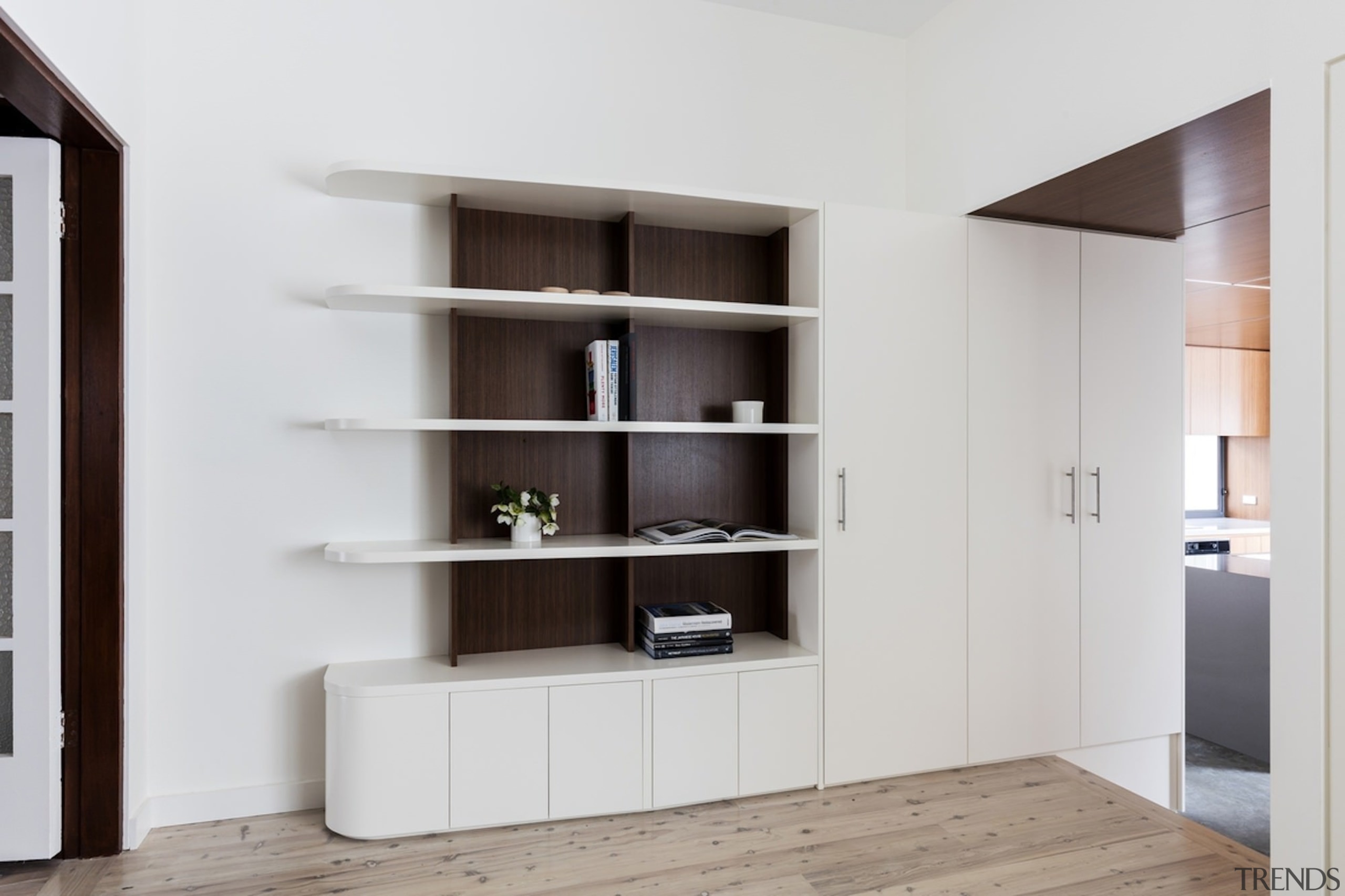 A tidy shelf unit merges into cupboards. - bookcase, furniture, interior design, shelf, shelving, gray, white