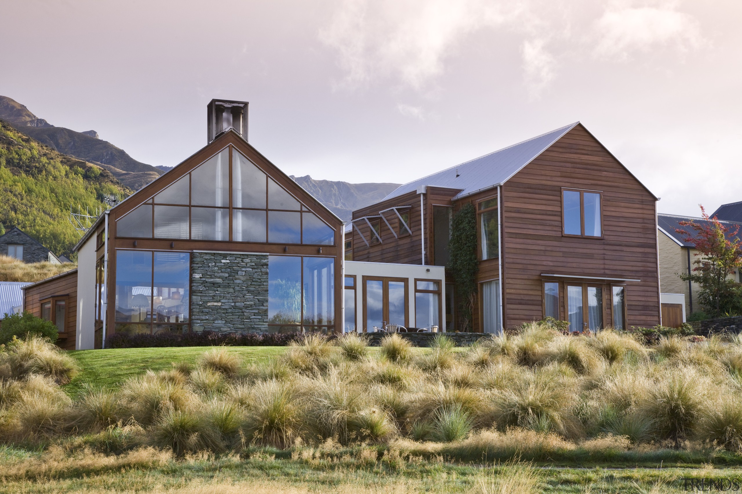 Exterior view of home which is clad with cottage, estate, farmhouse, home, house, landscape, property, real estate, sky, wood, white, brown