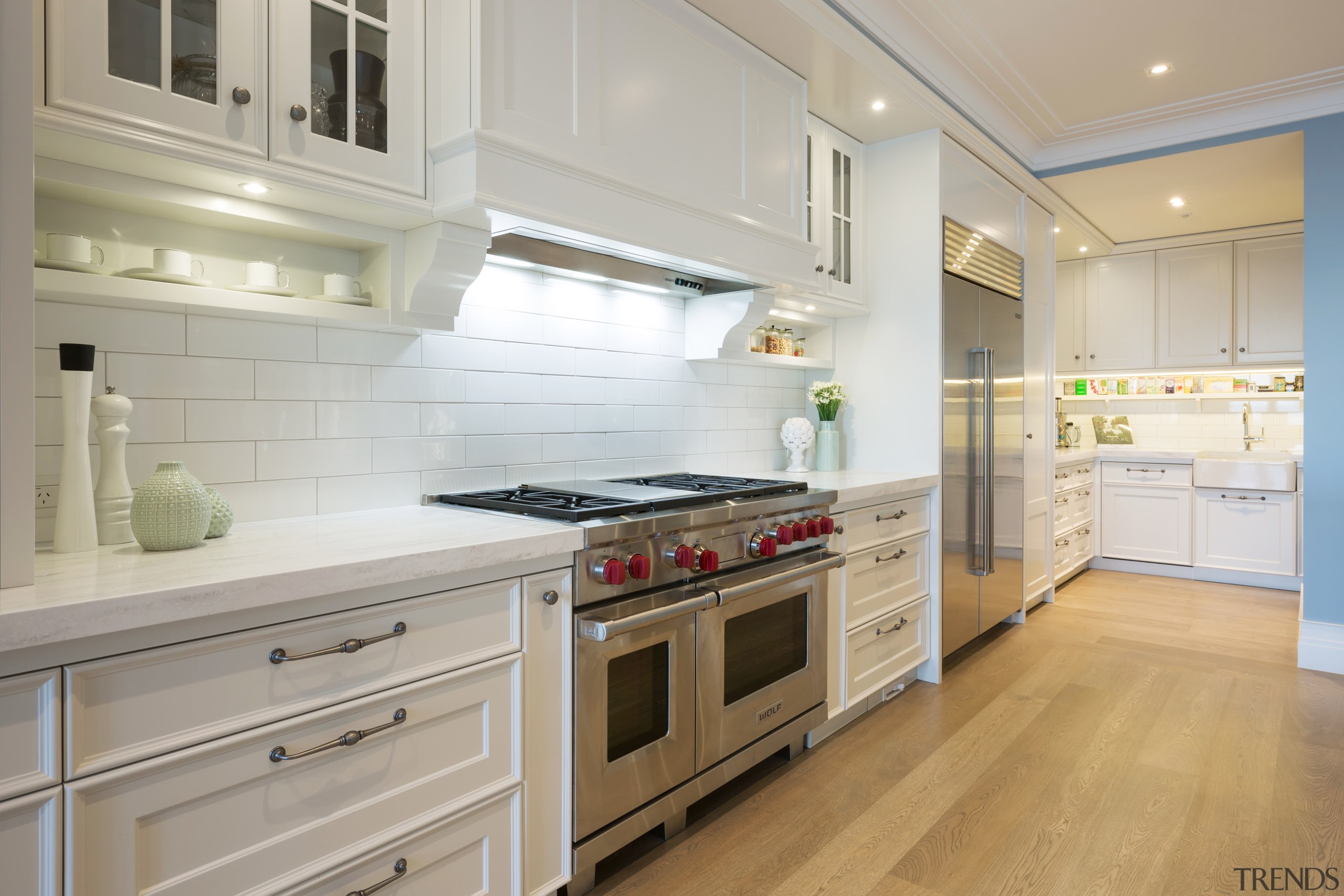 A crisp white subway tile forms the splashback cabinetry, countertop, cuisine classique, floor, flooring, home appliance, interior design, kitchen, room, gray