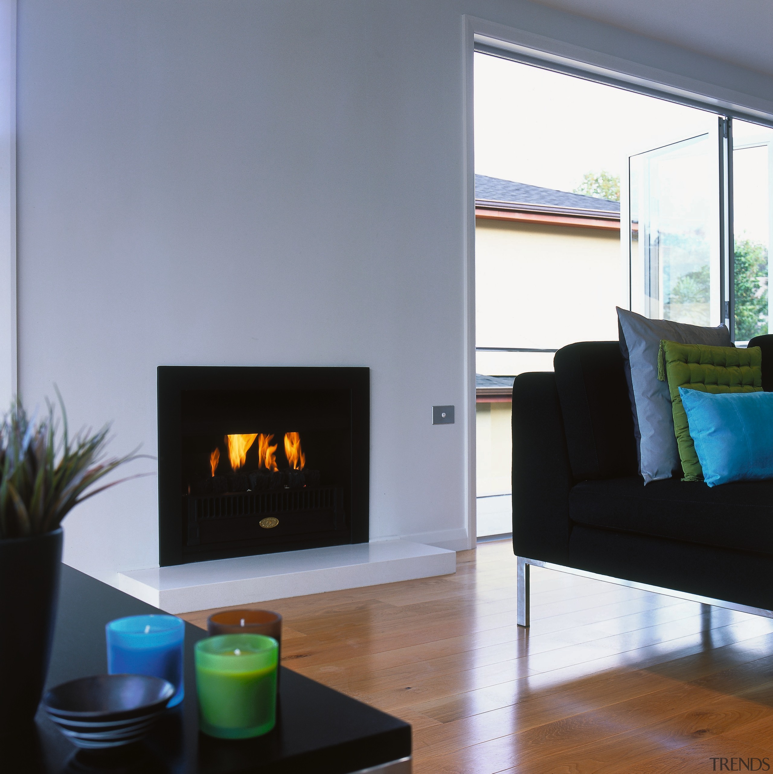 Fireplace set into white wall in lounge setting, fireplace, hearth, heat, home, home appliance, interior design, living room, wood burning stove, gray