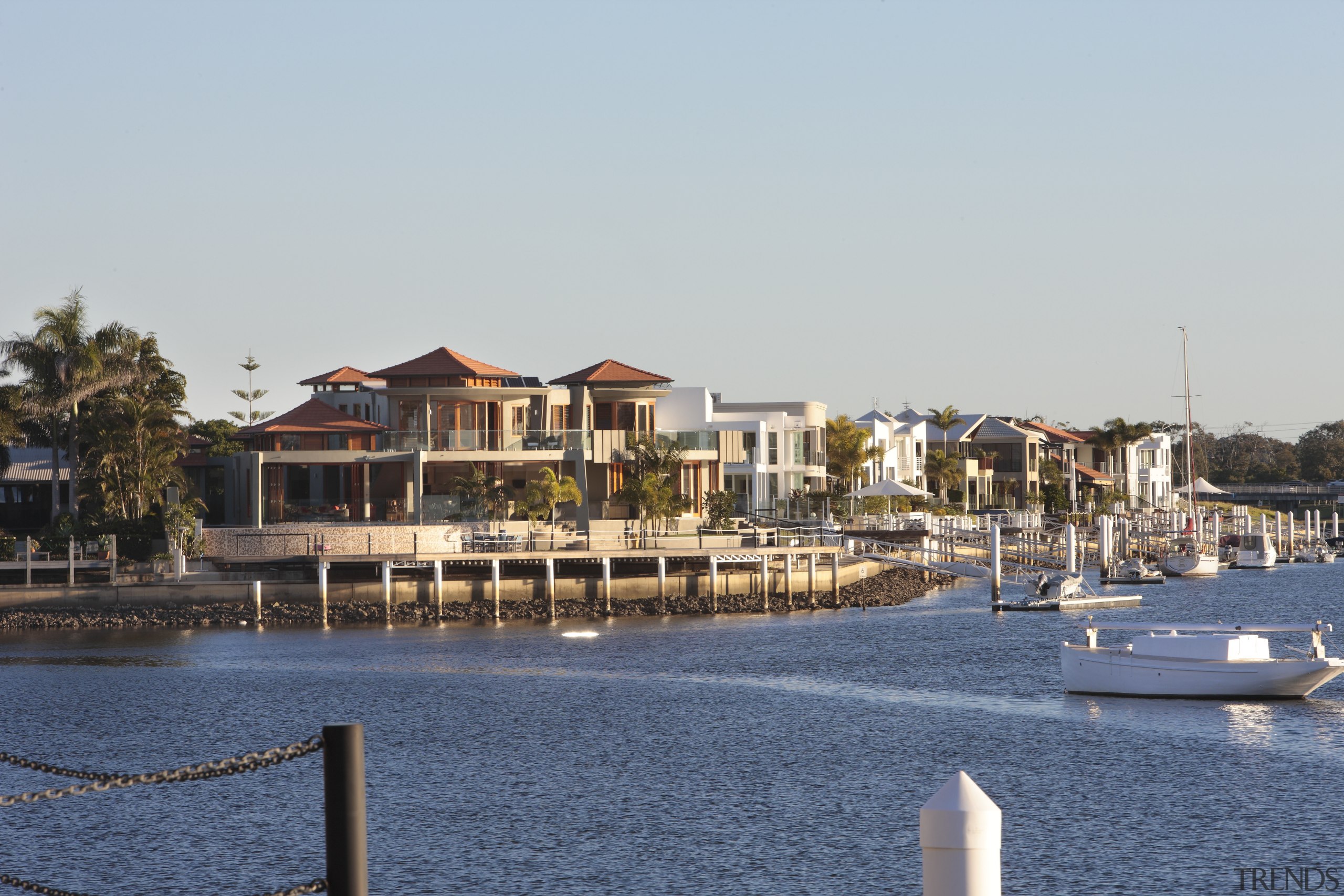 View of the exterior of this contemporary home boat, city, dock, harbor, home, marina, port, real estate, reflection, residential area, resort, sea, sky, tree, water, waterway, gray