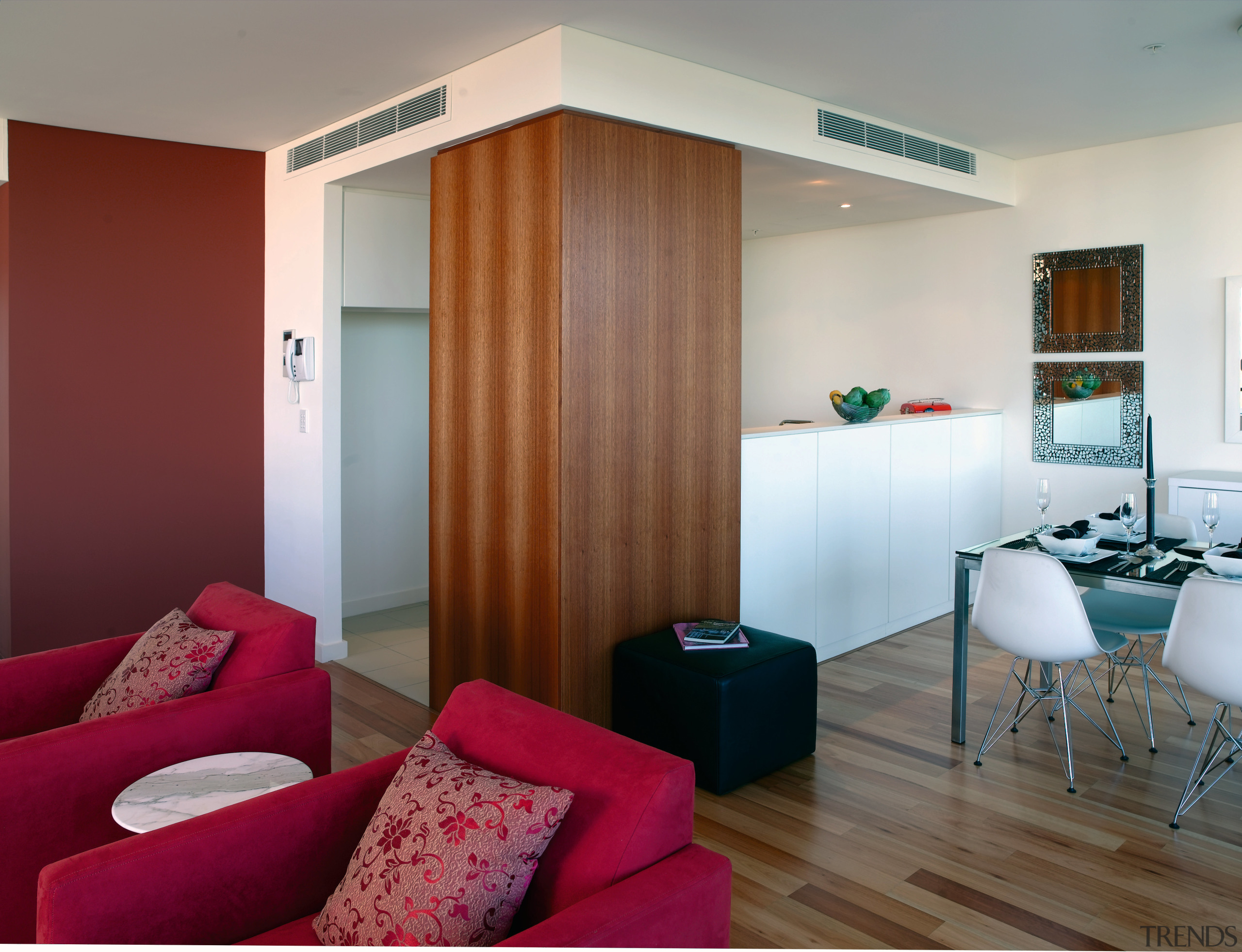 Timber detailing and a red-brown accent wall bring apartment, architecture, ceiling, door, floor, interior design, living room, real estate, room, suite, wall, red, gray