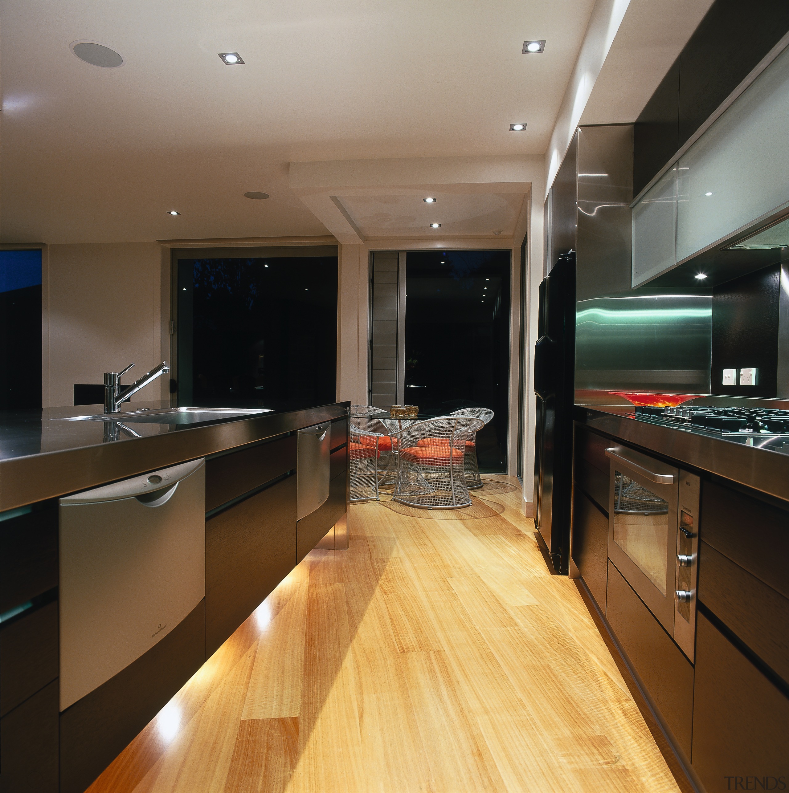 The view of a kitchen and dining area cabinetry, ceiling, countertop, floor, flooring, hardwood, interior design, kitchen, real estate, room, under cabinet lighting, wood flooring, brown, black