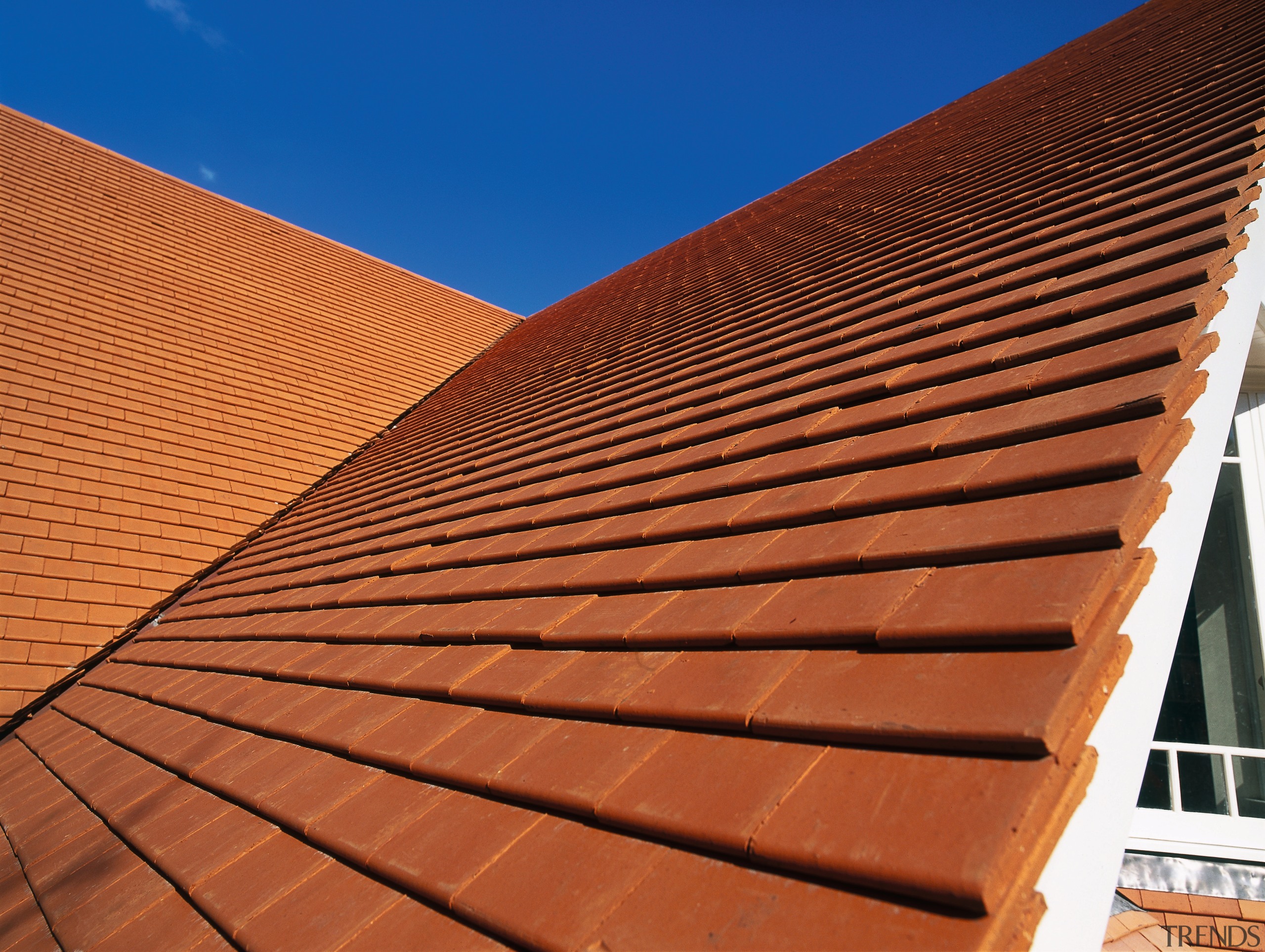 Steep pitched roof with orange roofing tiles. - angle, architecture, brick, brickwork, daylighting, facade, line, outdoor structure, roof, sky, sunlight, wall, wood, wood stain, red, brown