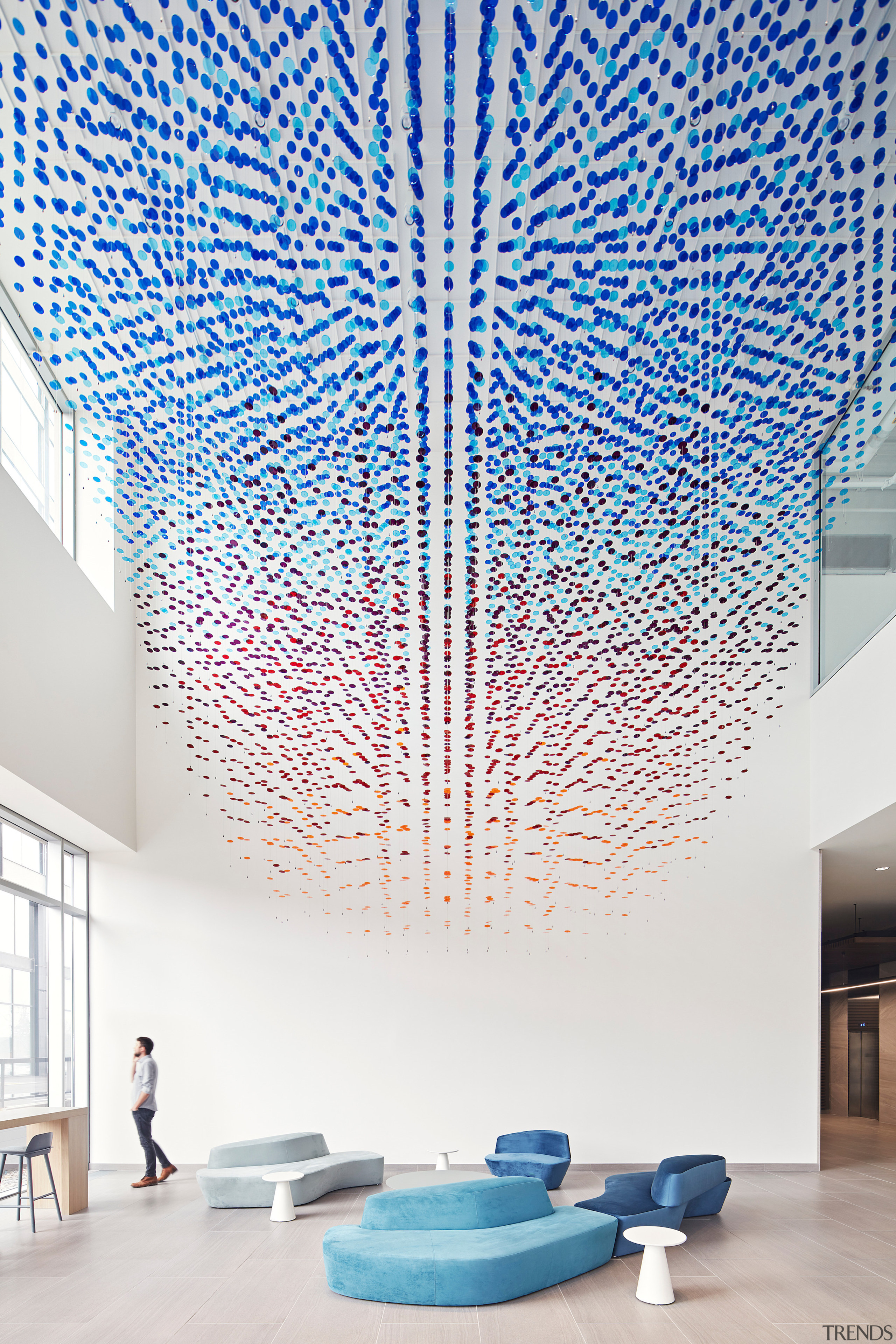 The porous installation breaks the triple-height lobby into 