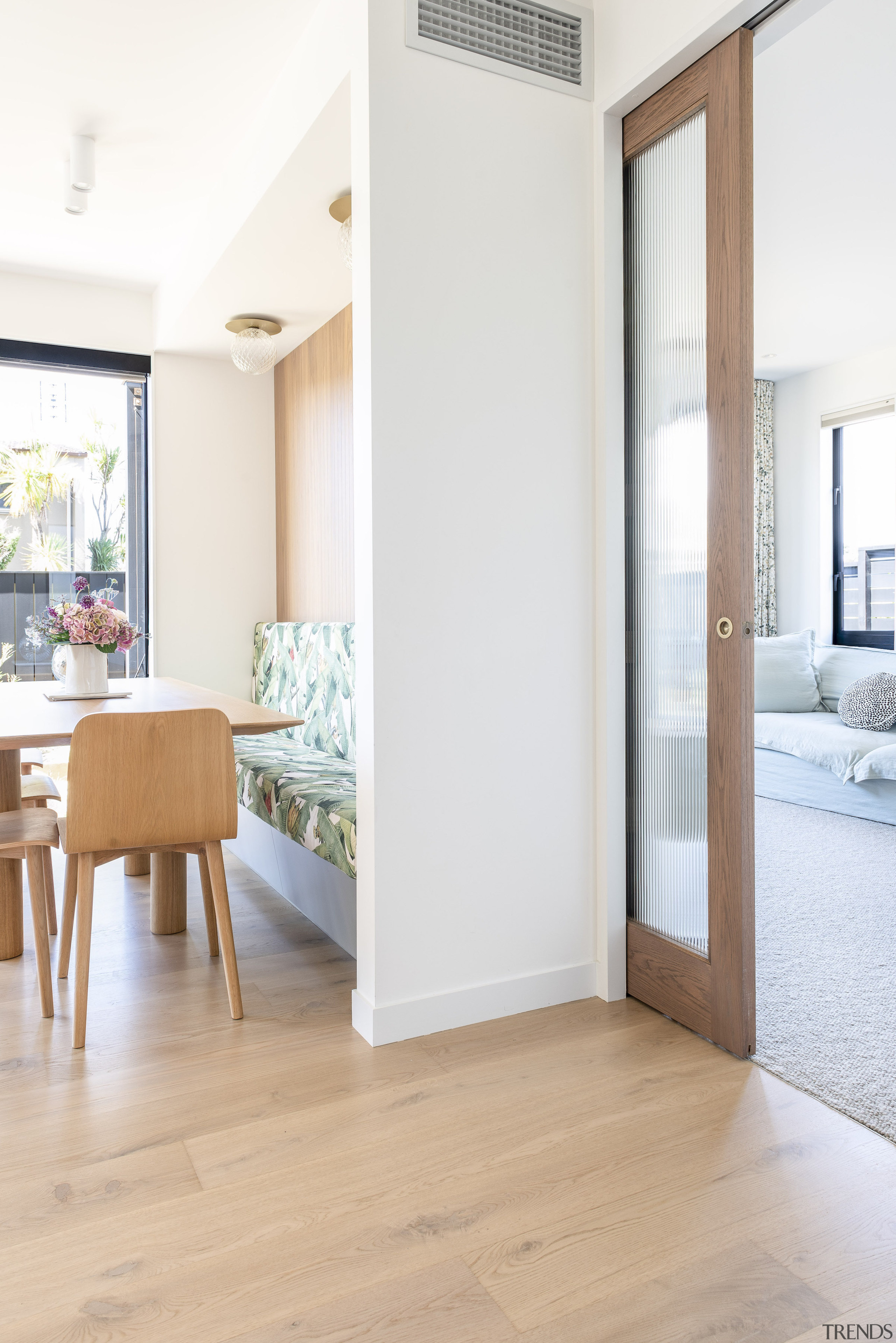 A wood-framed, reeded glass pocket sliding door separates 