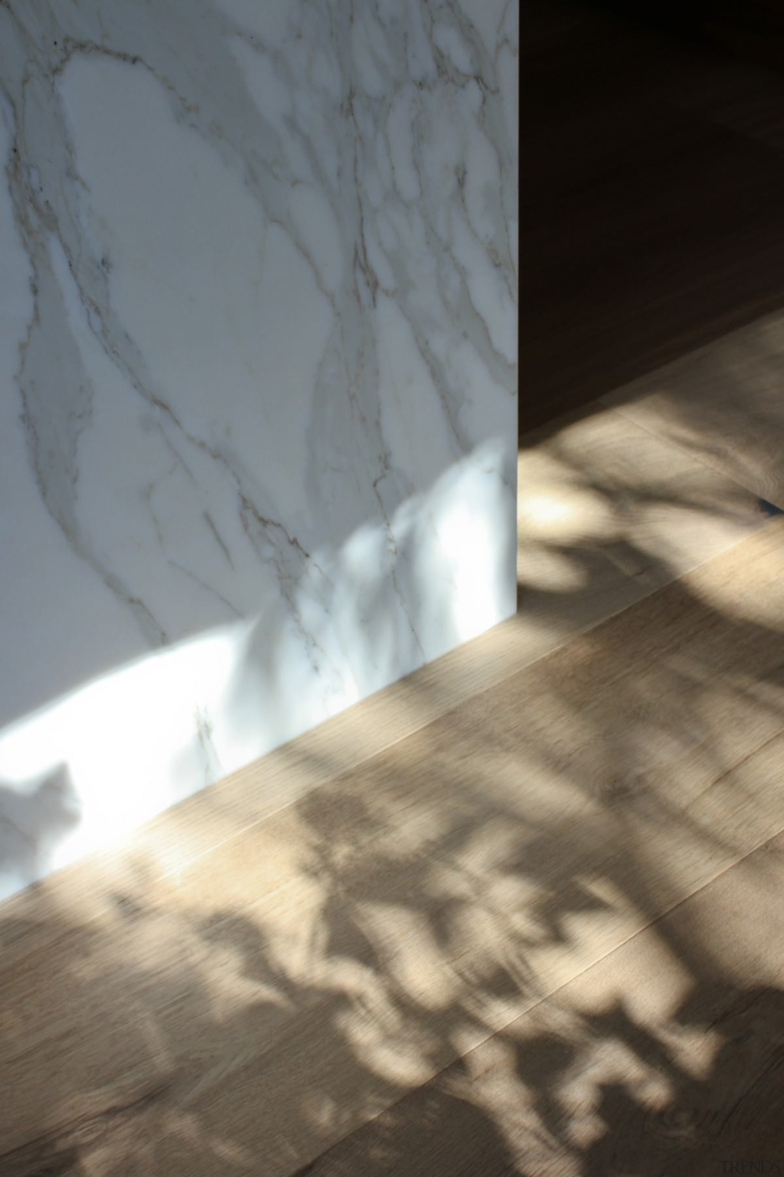 A close-up of where the island counter meets angle, atmosphere, daylighting, floor, light, line, reflection, shadow, sky, sunlight, texture, wall, wood, gray, brown