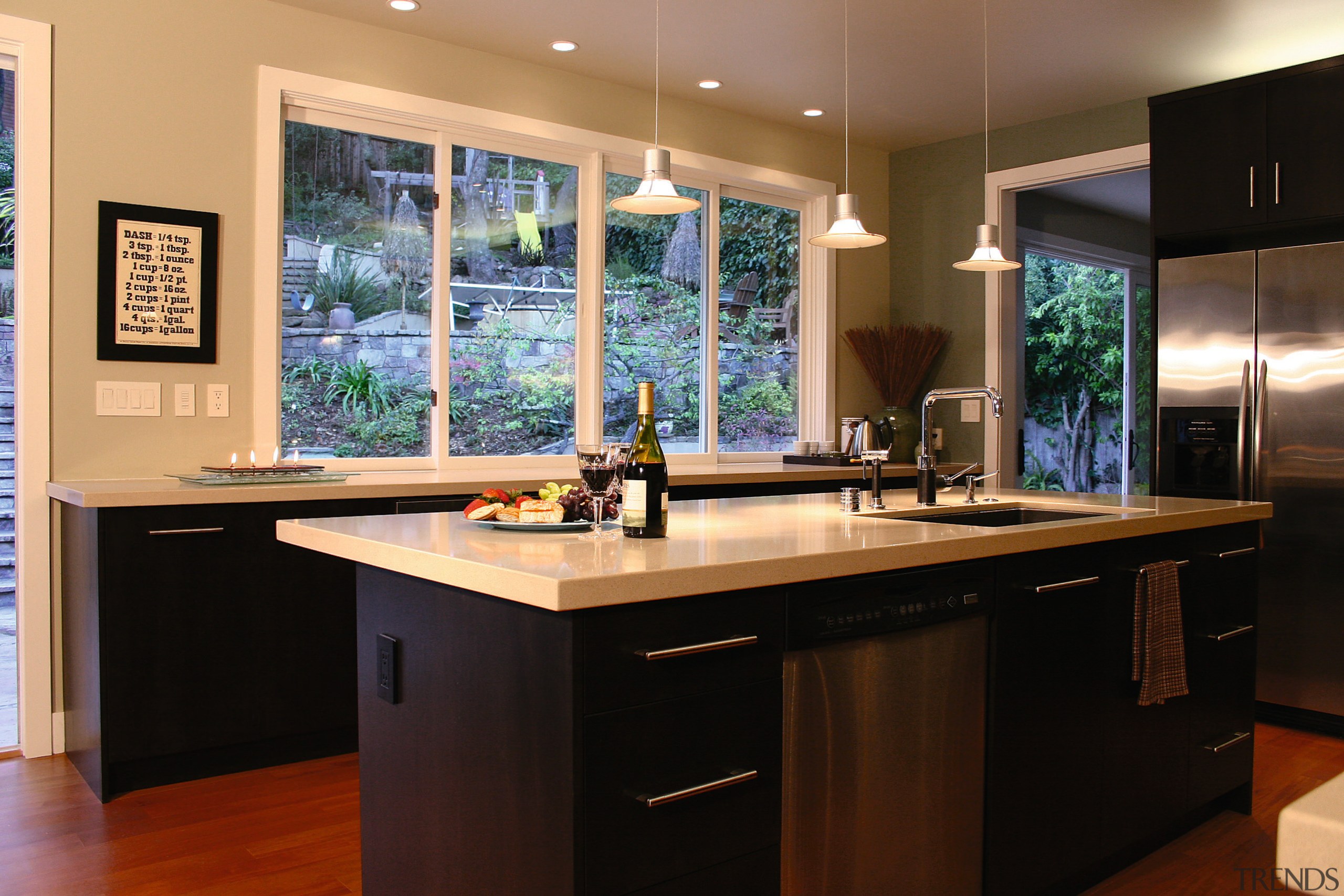 View of this kitchen featuring stained timber flooring, cabinetry, countertop, interior design, kitchen, real estate, room, window, black