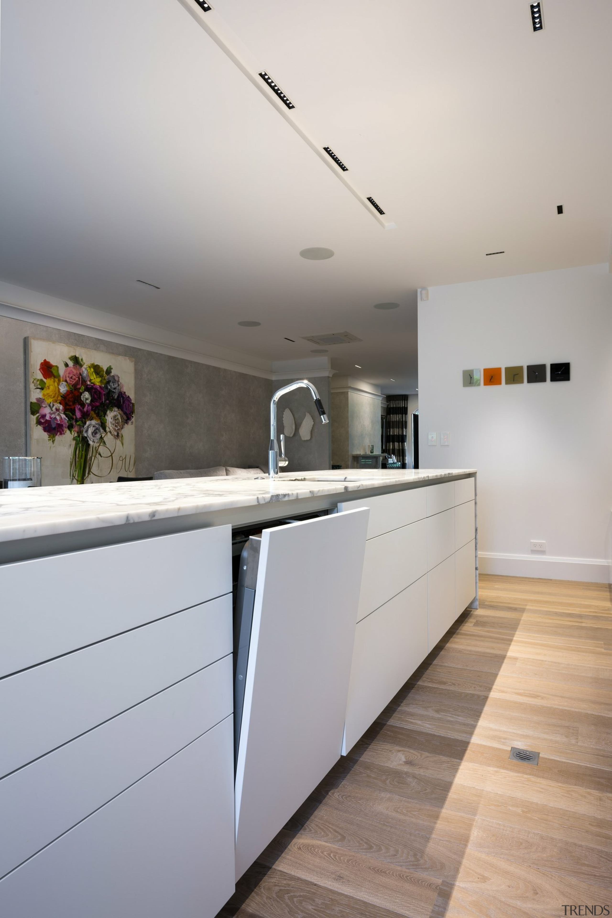 The handleless, high-gloss white cabinetry offsets the kitchen's 