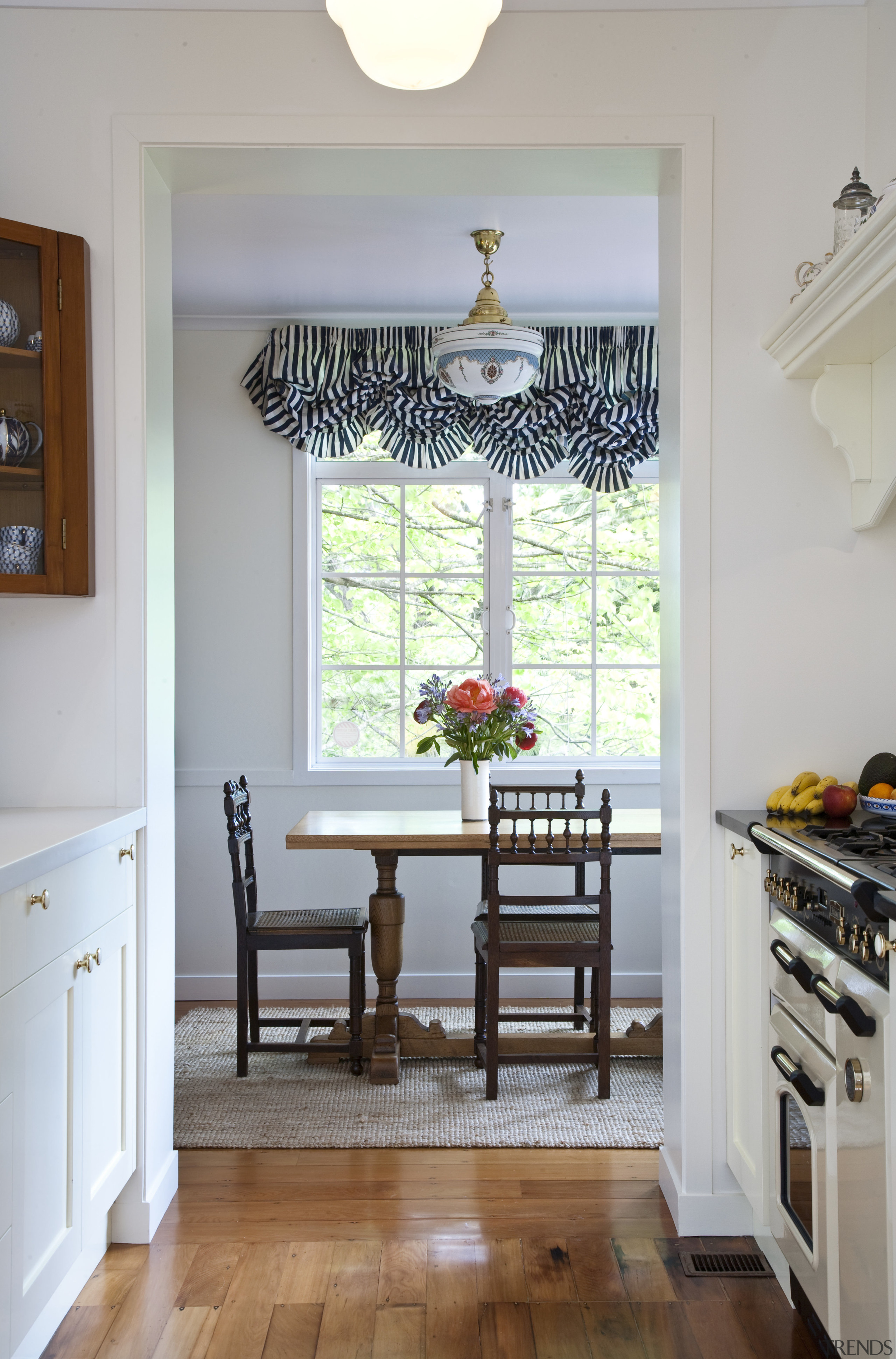 View of dining room through kitchen showing existing cabinetry, chair, dining room, door, floor, furniture, hardwood, home, house, interior design, kitchen, living room, room, shelf, shelving, table, wall, window, window covering, window treatment, wood, gray