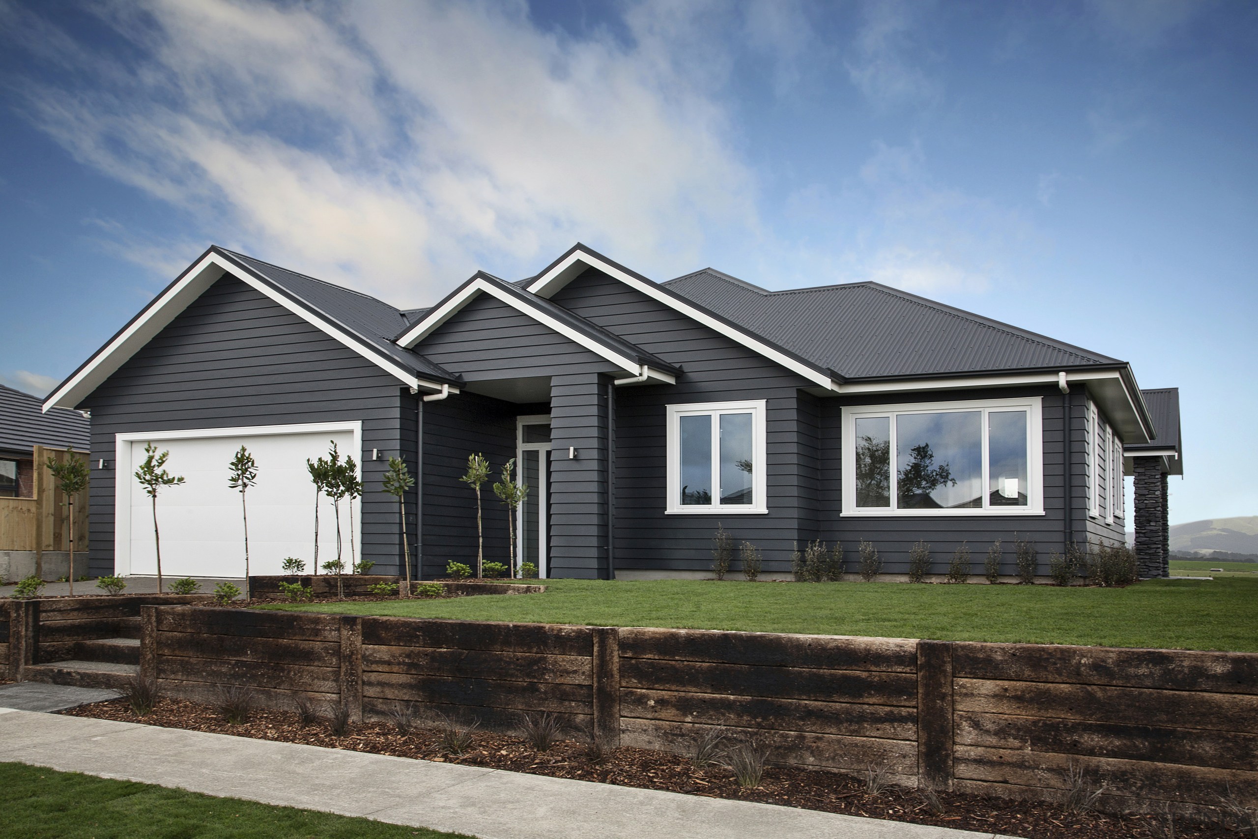 Landmark Homes new showhome, the Rata, is as building, cottage, elevation, estate, facade, farmhouse, home, house, landscape, property, real estate, residential area, siding, sky, suburb, gray, black