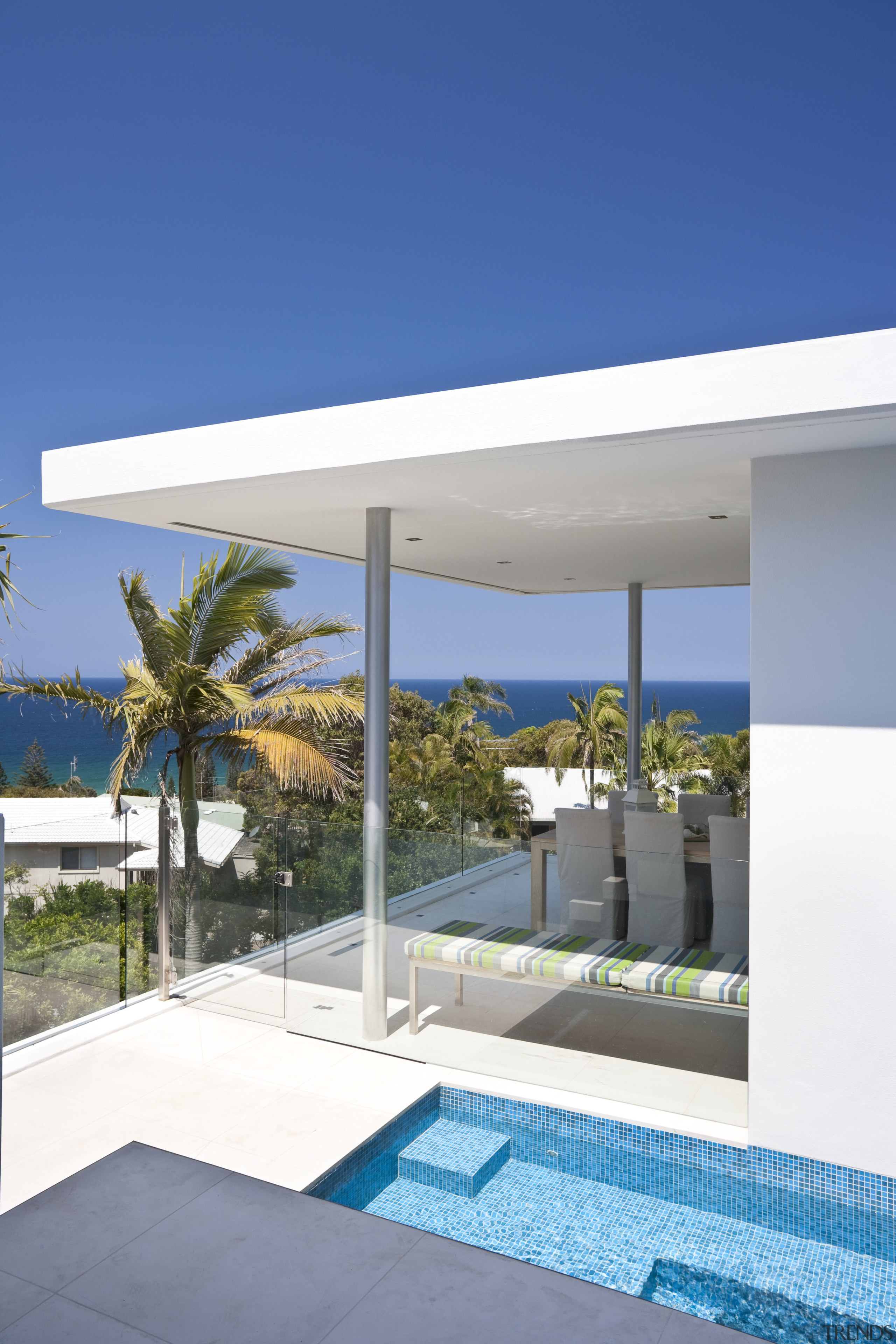 View of rooftop terrace which features paving, outdoor architecture, home, house, property, real estate, sky, swimming pool, blue, white