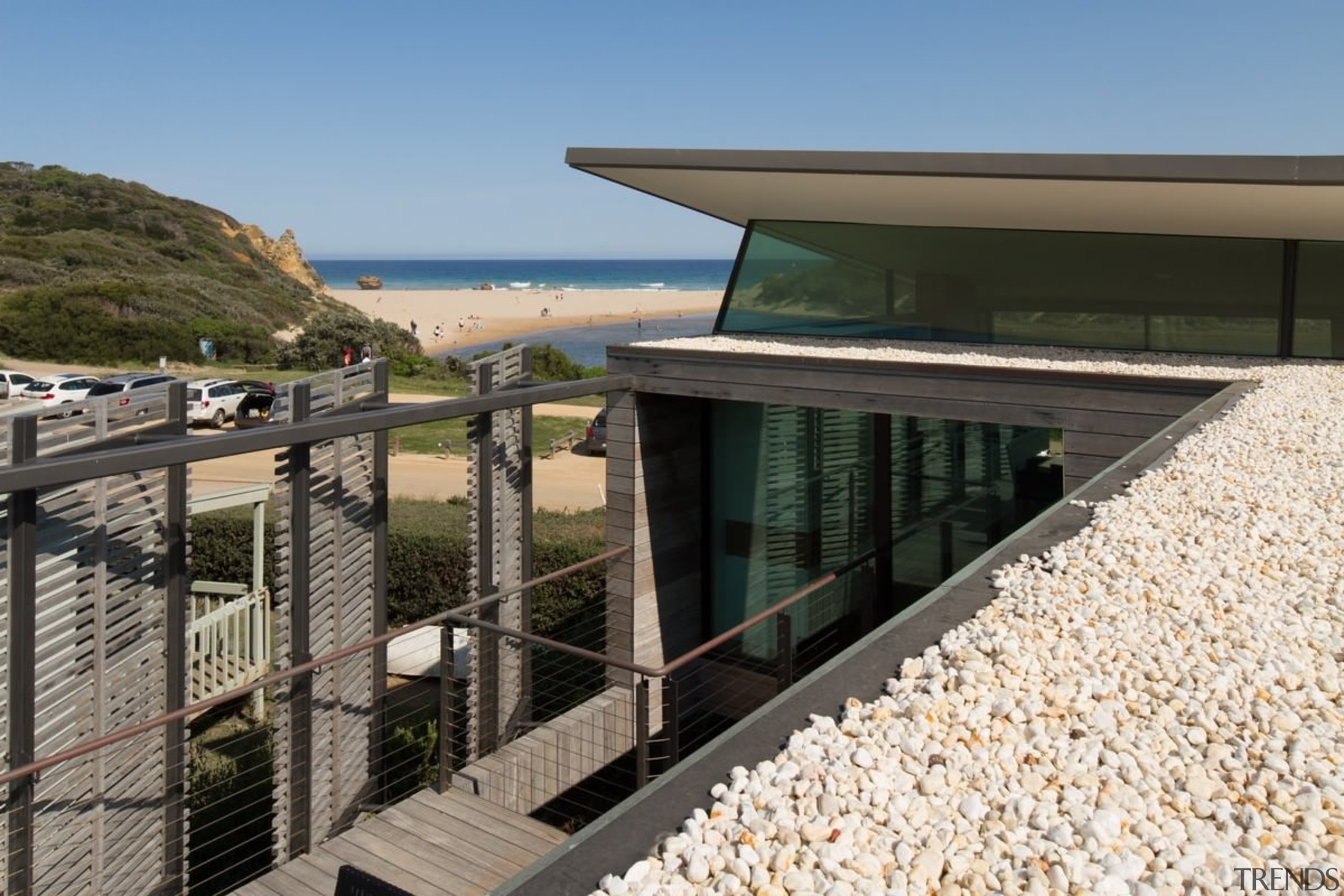 The roof echoes the nearby beach. The house architecture, handrail, house, property, real estate, walkway, black
