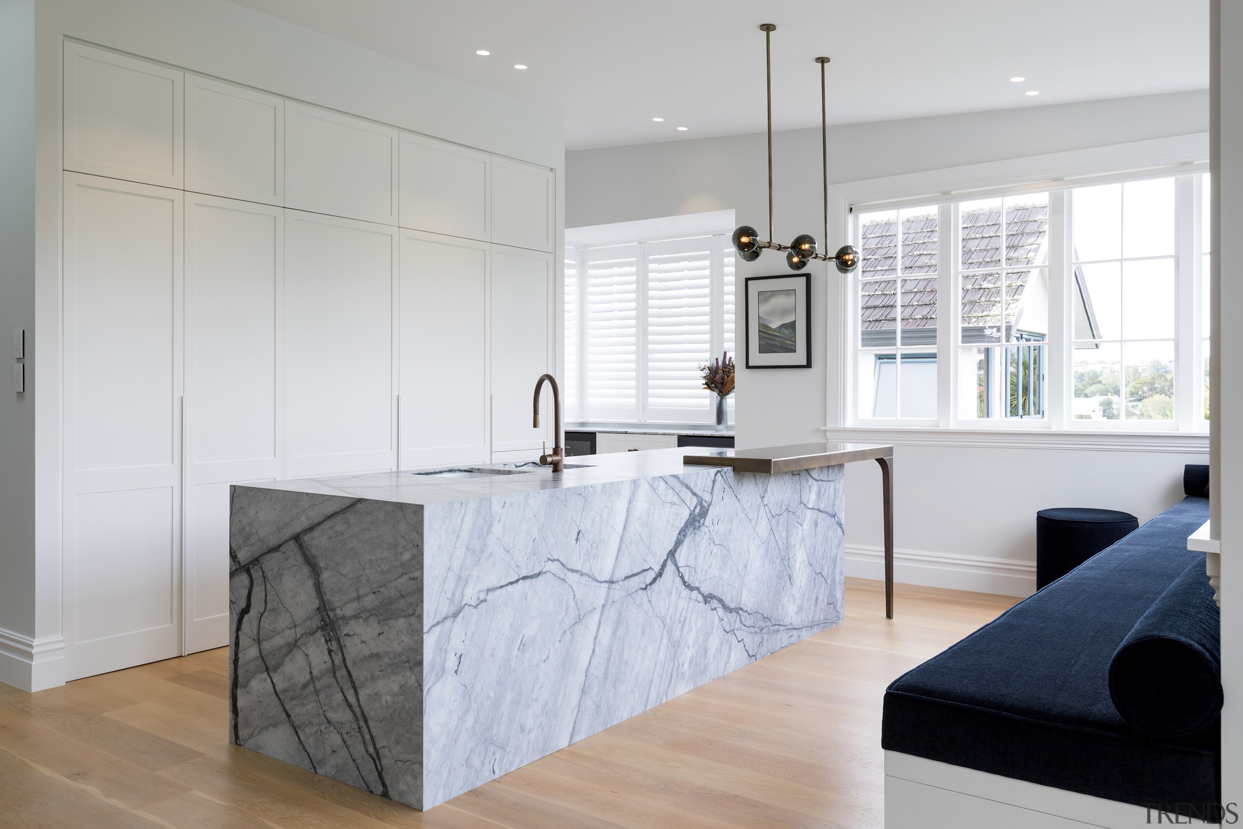 A handle-less floor-to-ceiling wall of white cabinetry provides 