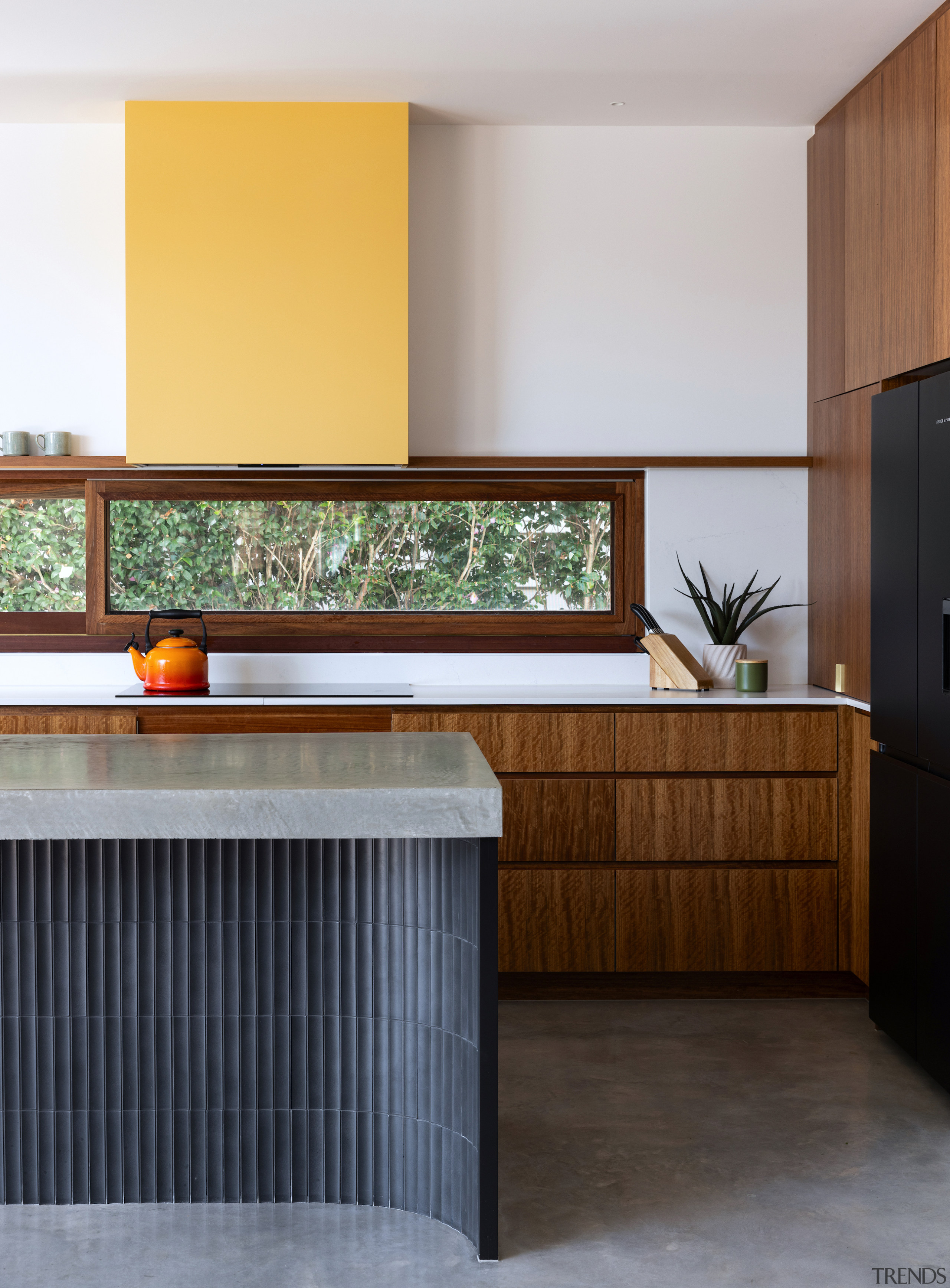 The island's robust concrete benchtop and matte black 