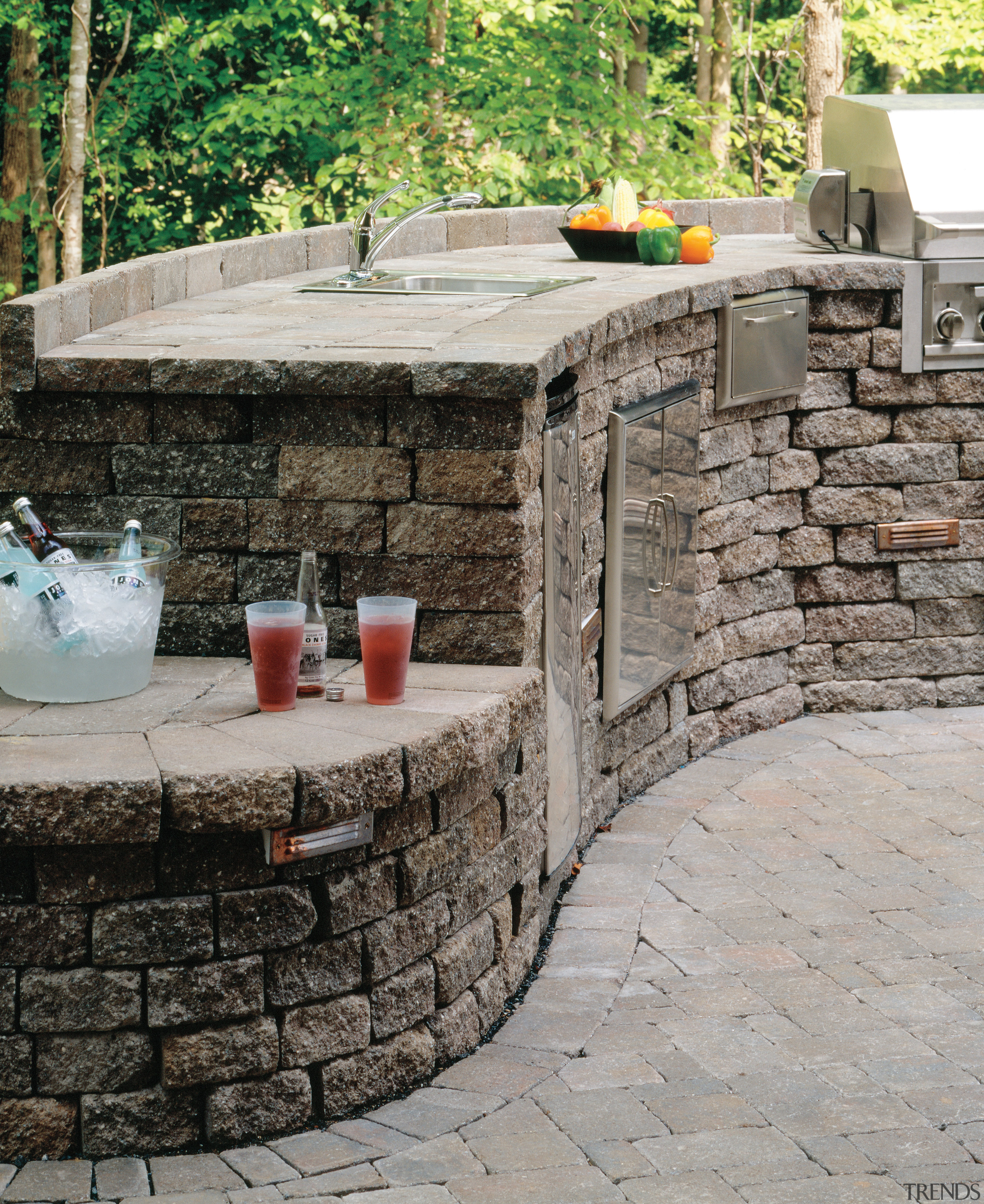 A view of these outdoor entertainment areas featuring backyard, flagstone, outdoor structure, patio, stone wall, walkway, wall, gray