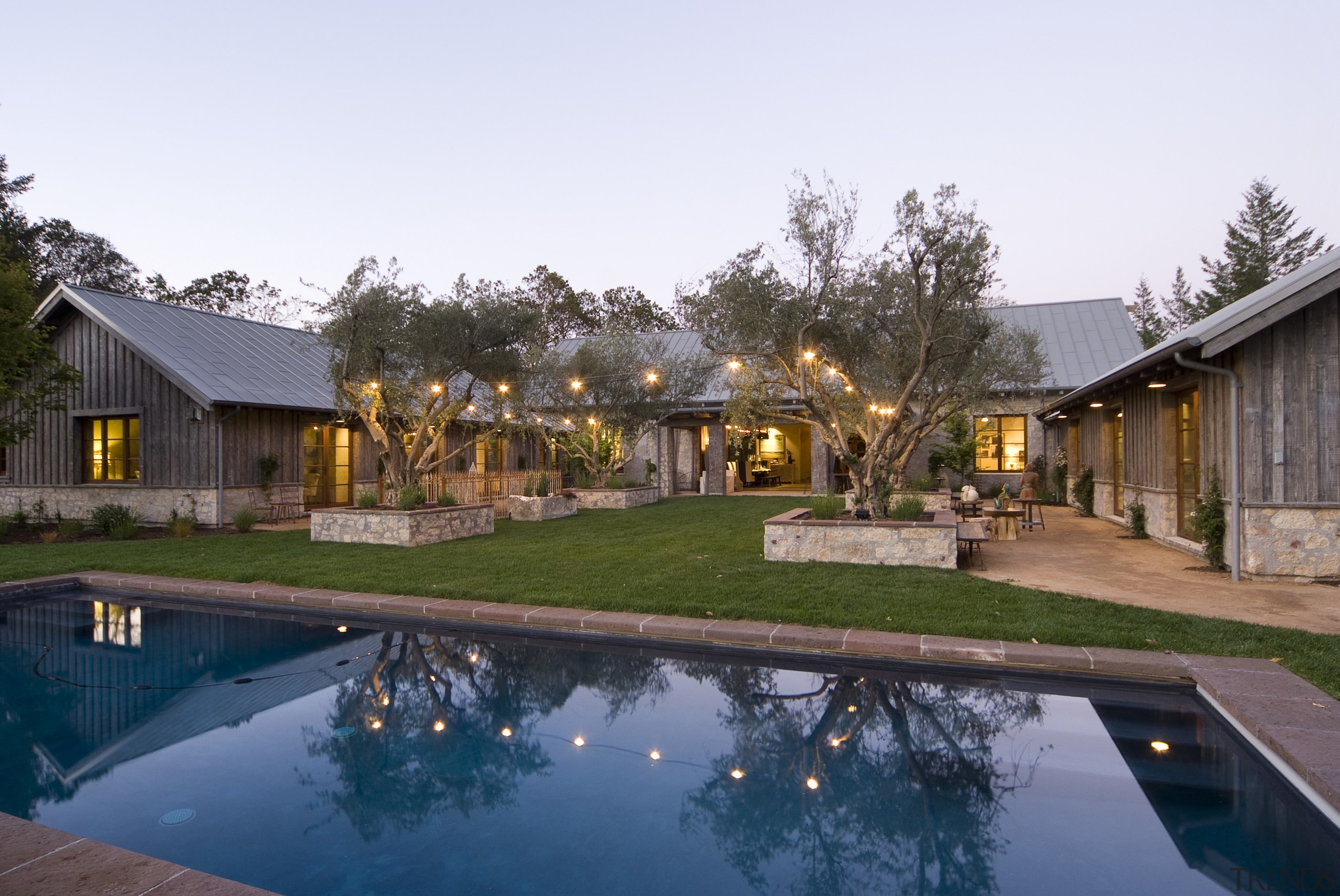 Rustic house modelled on French barn. Interiors feature backyard, cottage, estate, home, house, leisure, property, real estate, reflection, residential area, resort, swimming pool, villa, white