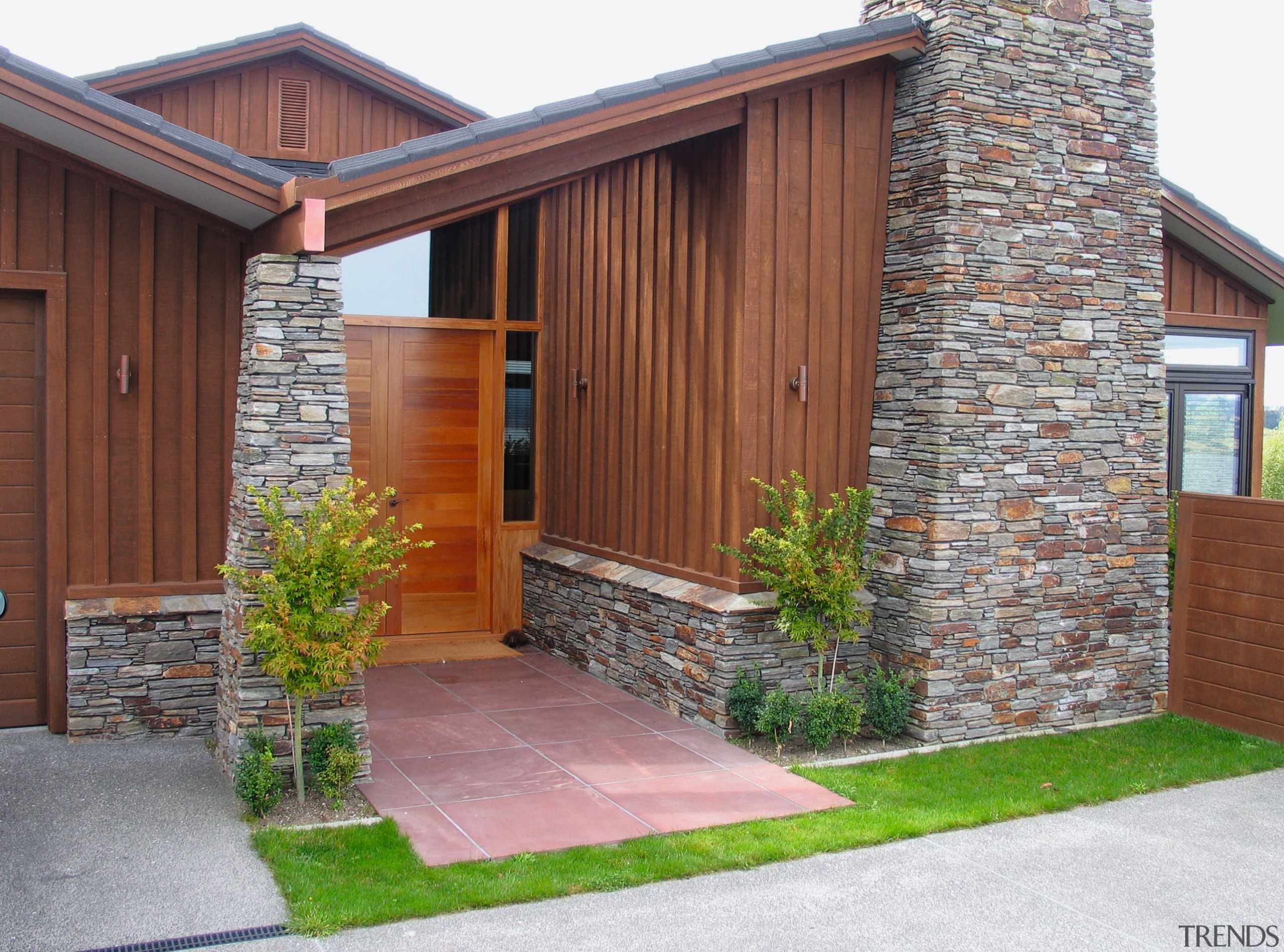 view of this home that features the shadowclad brickwork, door, facade, home, house, property, real estate, residential area, shed, siding, window, gray