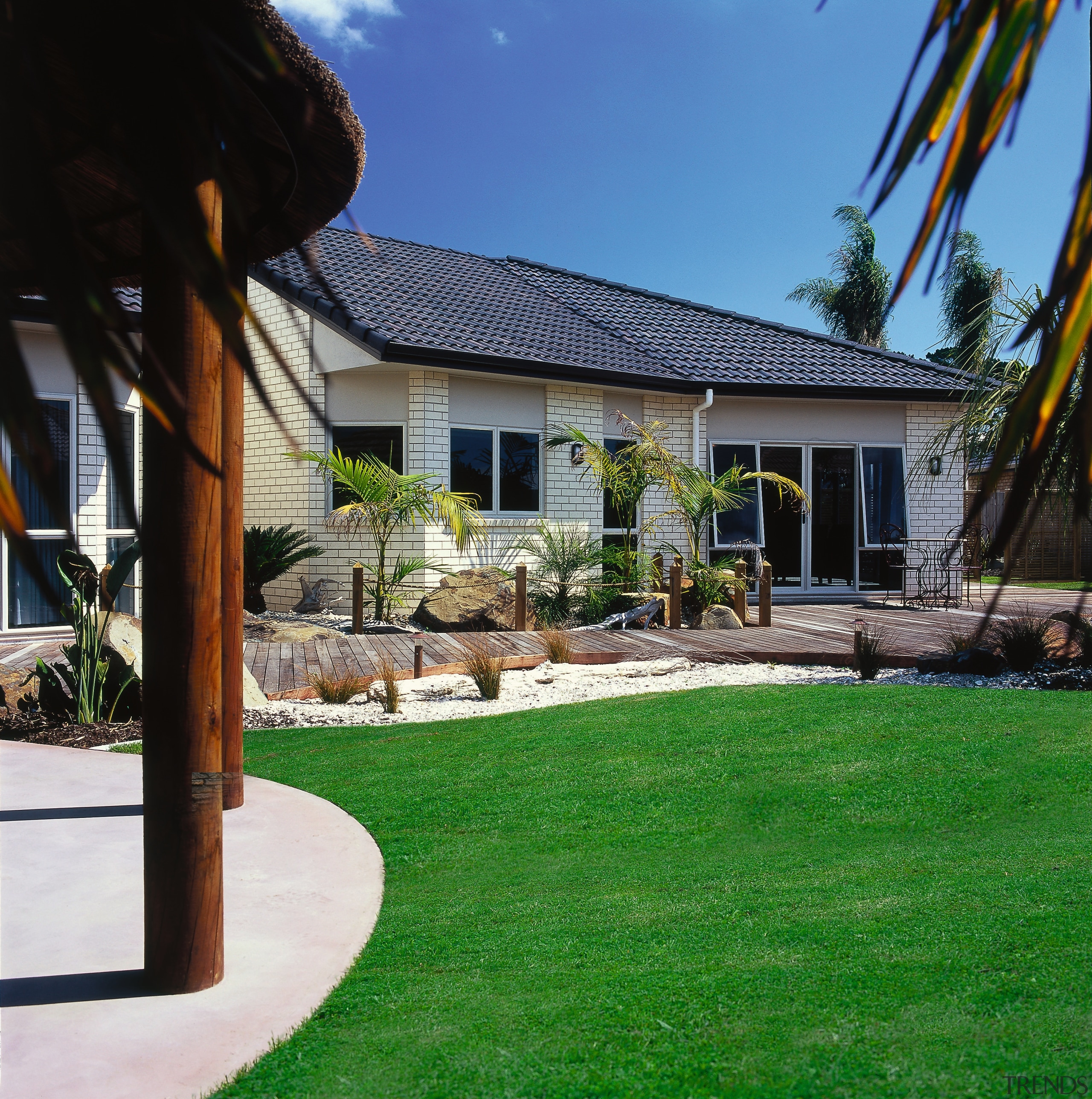 View of the outdoor area of this home backyard, cottage, estate, facade, grass, home, house, landscape, landscaping, lawn, outdoor structure, plant, property, real estate, residential area, roof, siding, yard, black, green