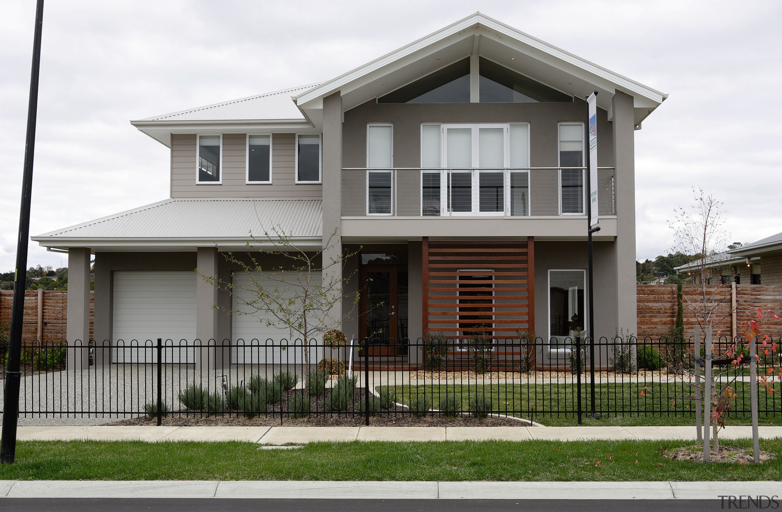 Exterior view of two storey home with wrought building, cottage, elevation, estate, facade, home, house, neighbourhood, property, real estate, residential area, siding, suburb, white, gray