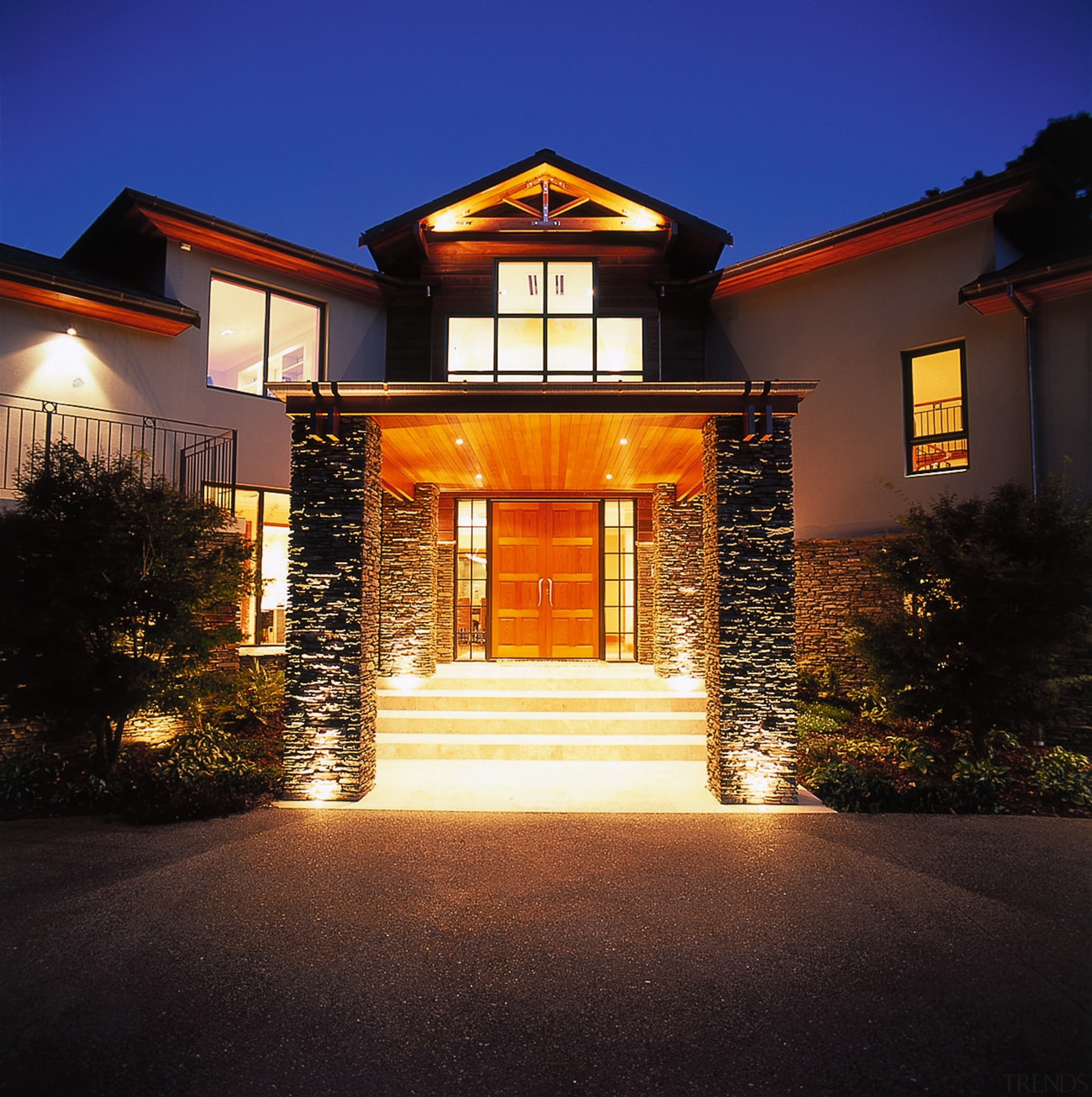 View of the lakehouse's entrance way. Features two architecture, building, estate, evening, facade, home, house, landscape lighting, lighting, mansion, night, property, real estate, residential area, sky, window, black