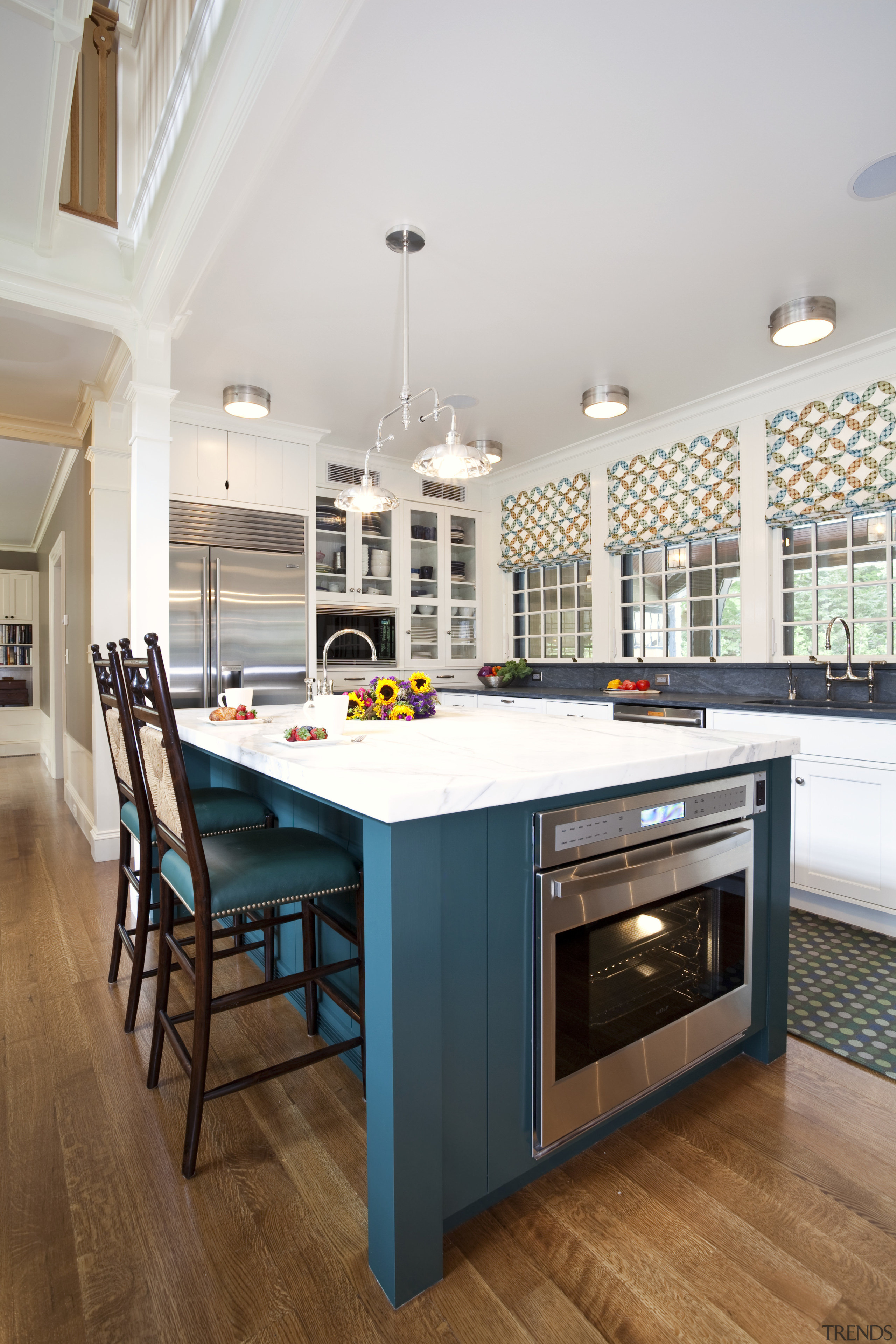 View of kitchen with dark turquoise island, colorful cabinetry, countertop, floor, flooring, hardwood, interior design, kitchen, real estate, room, table, wood flooring, white