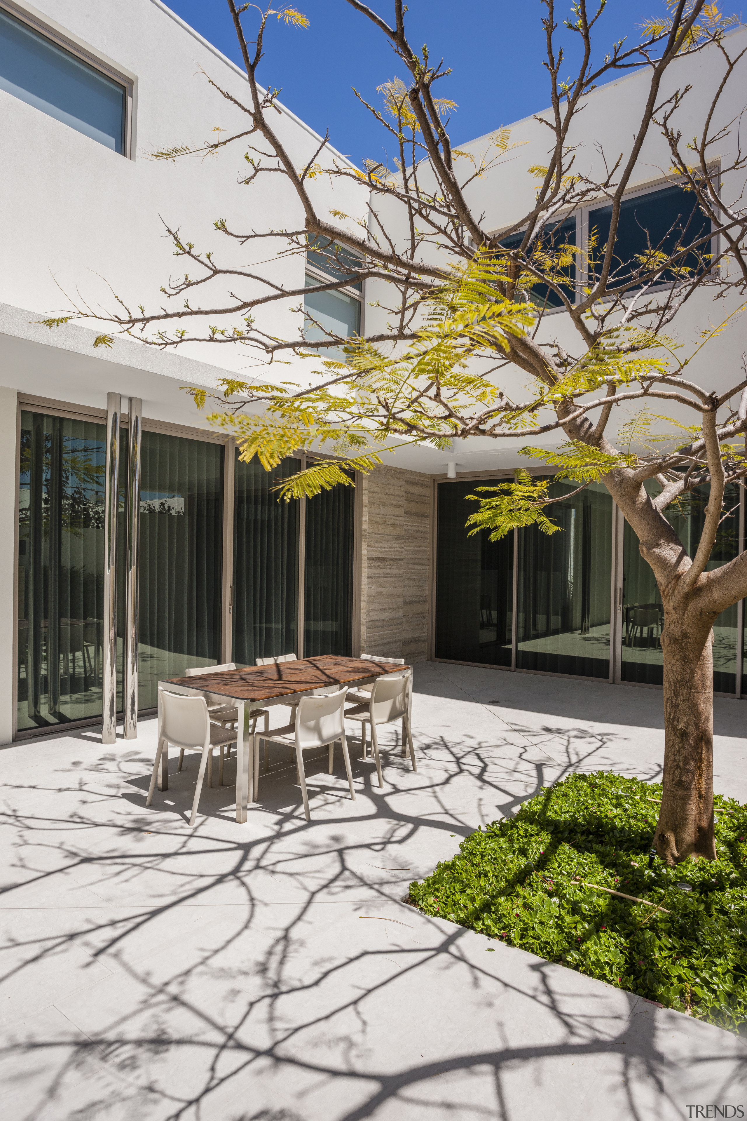 For this new home, landscape features include a architecture, backyard, courtyard, facade, home, house, outdoor structure, patio, property, real estate, residential area, tree, white