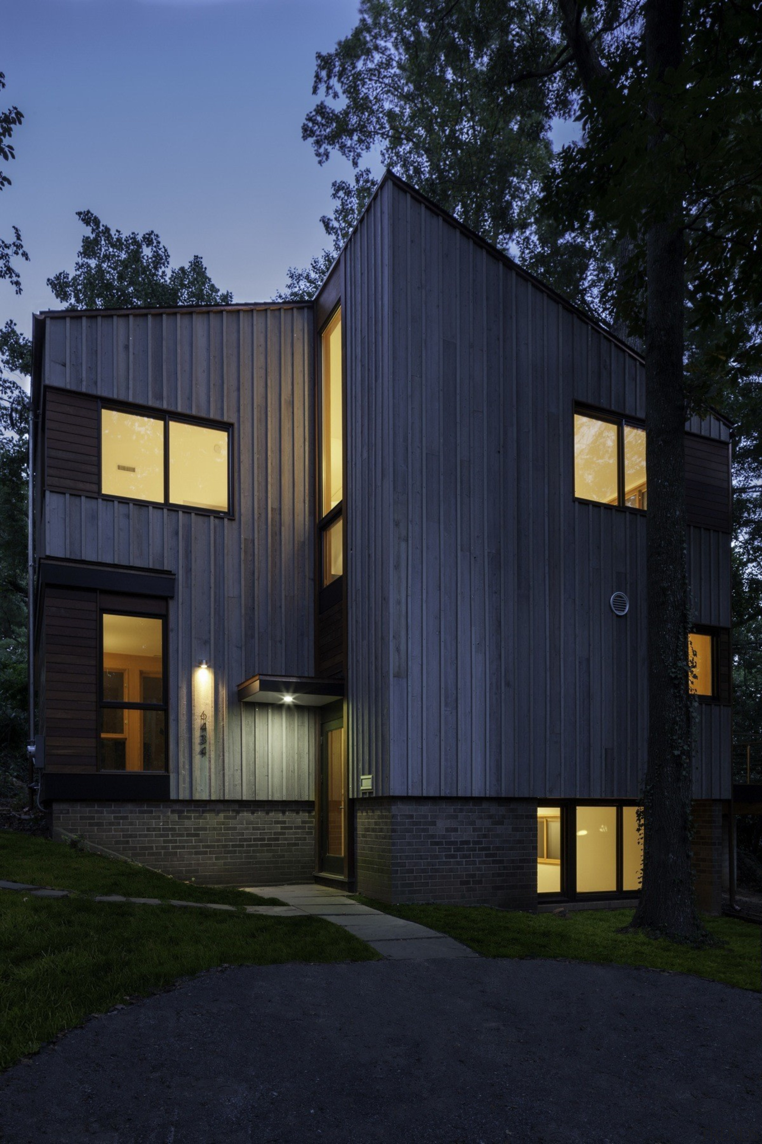 A subtle entrance sits tucked into the side architecture, building, facade, home, house, property, real estate, shed, siding, black