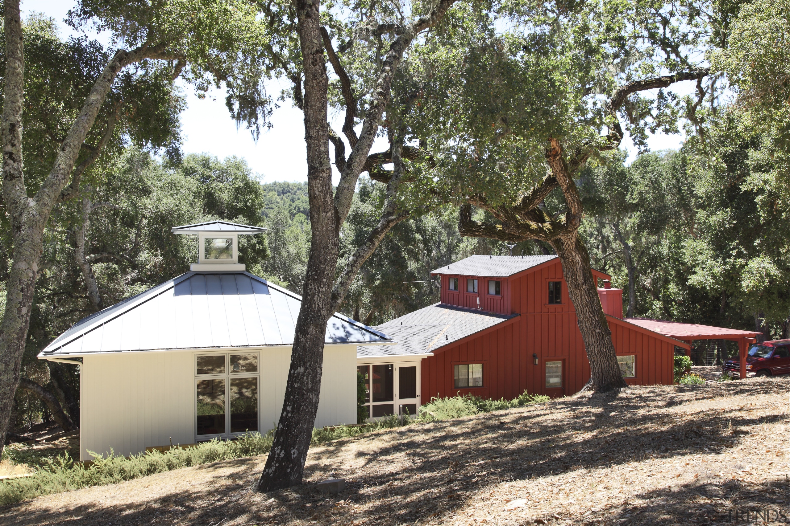 View of red and white buildings with trees. cottage, home, house, hut, plant, property, real estate, tree