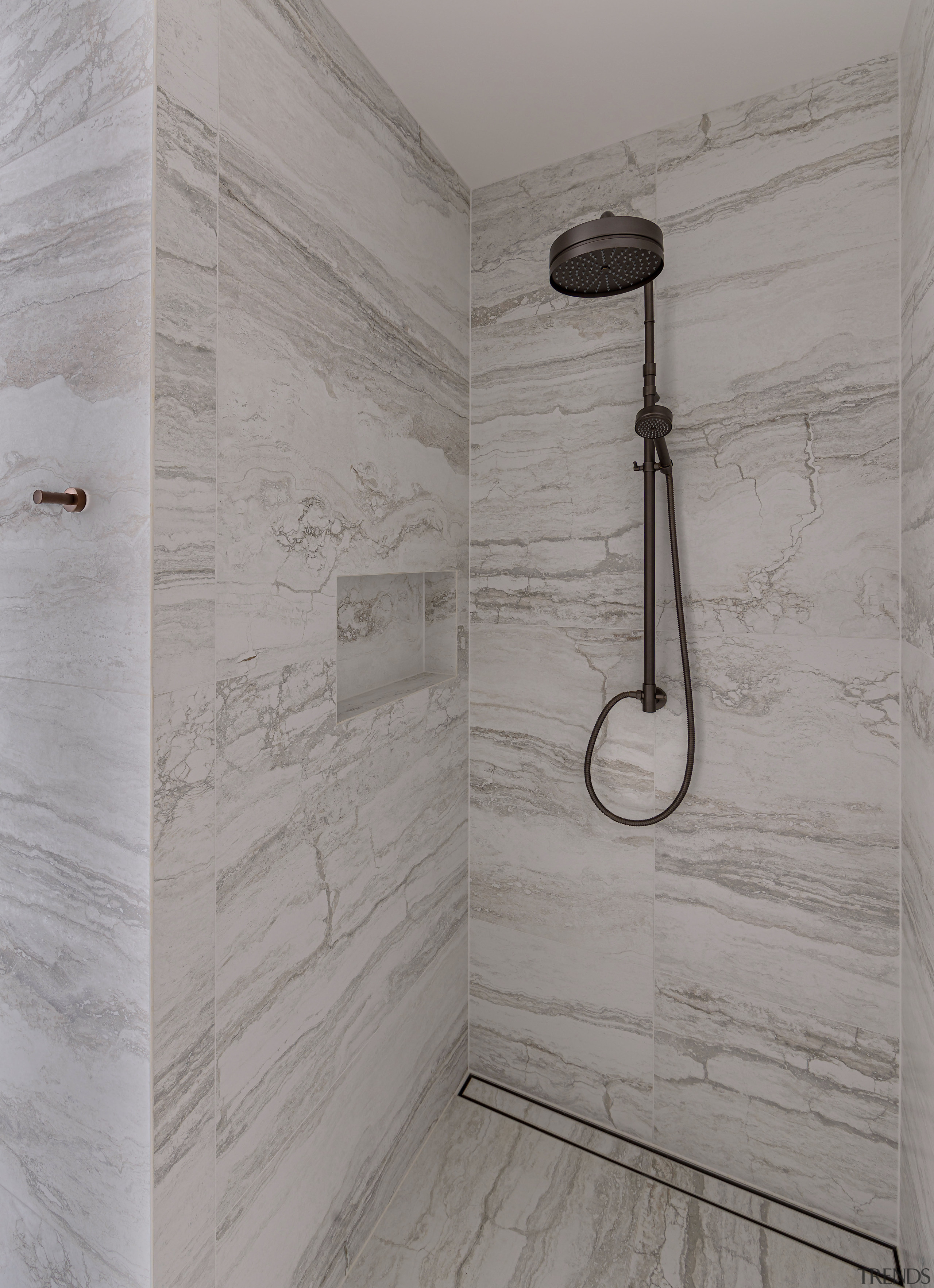 Large-format Travertine-look tiles establish the tone, accented by 