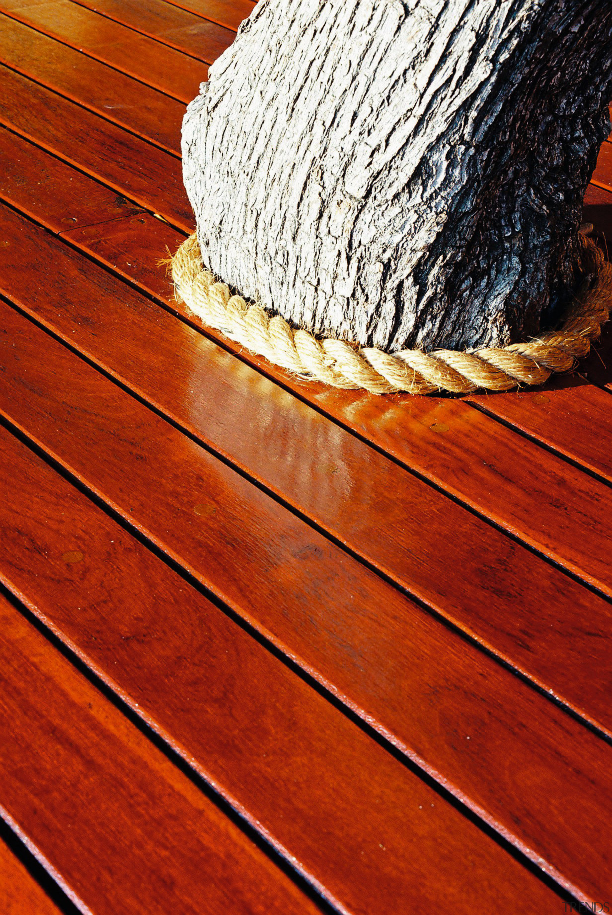 A view of some wooden decking. - A floor, flooring, hardwood, line, rope, wood, wood flooring, wood stain, yellow, red
