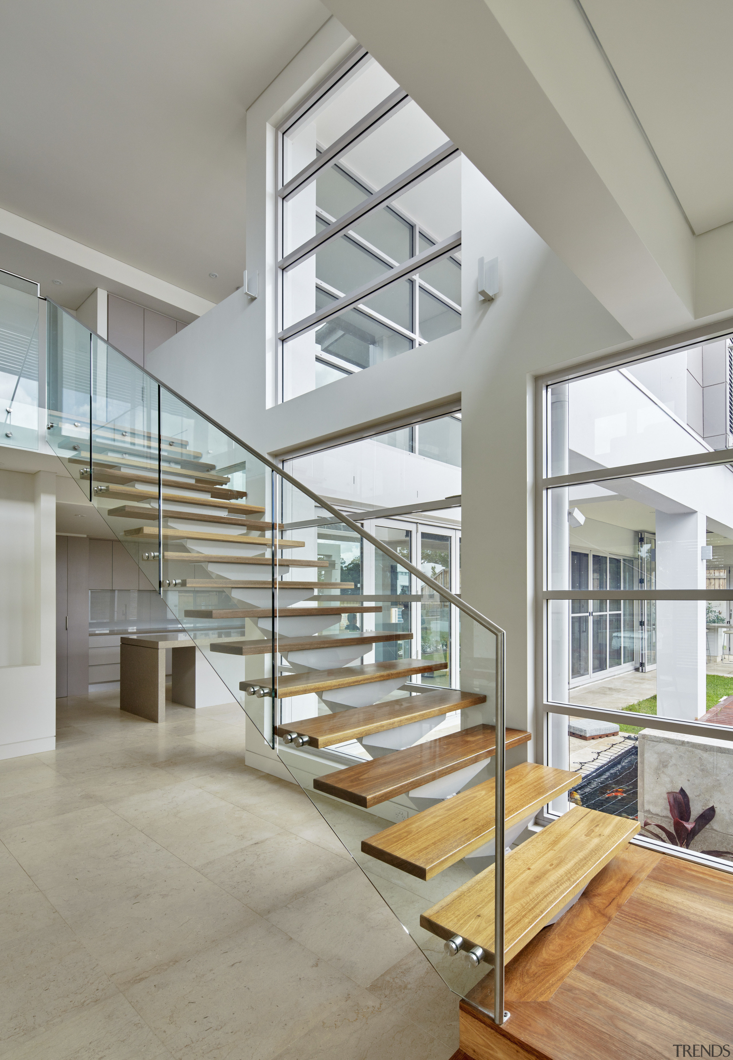 Soaring double-height voids create a light, airy interior architecture, condominium, daylighting, estate, floor, glass, handrail, home, house, interior design, real estate, stairs, gray