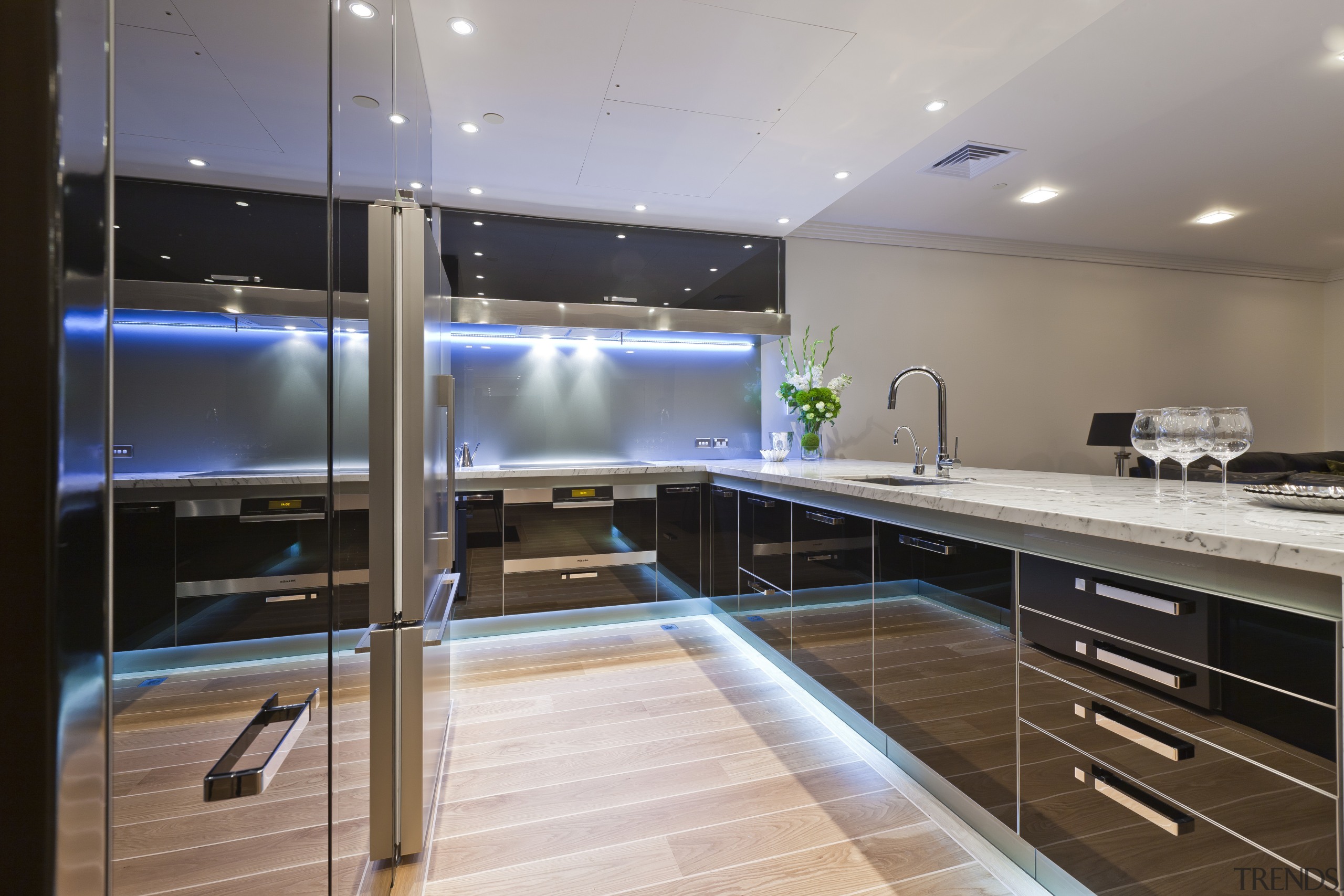 View of apartment kitchen with black glass cabinetry, cabinetry, countertop, interior design, kitchen, gray, black