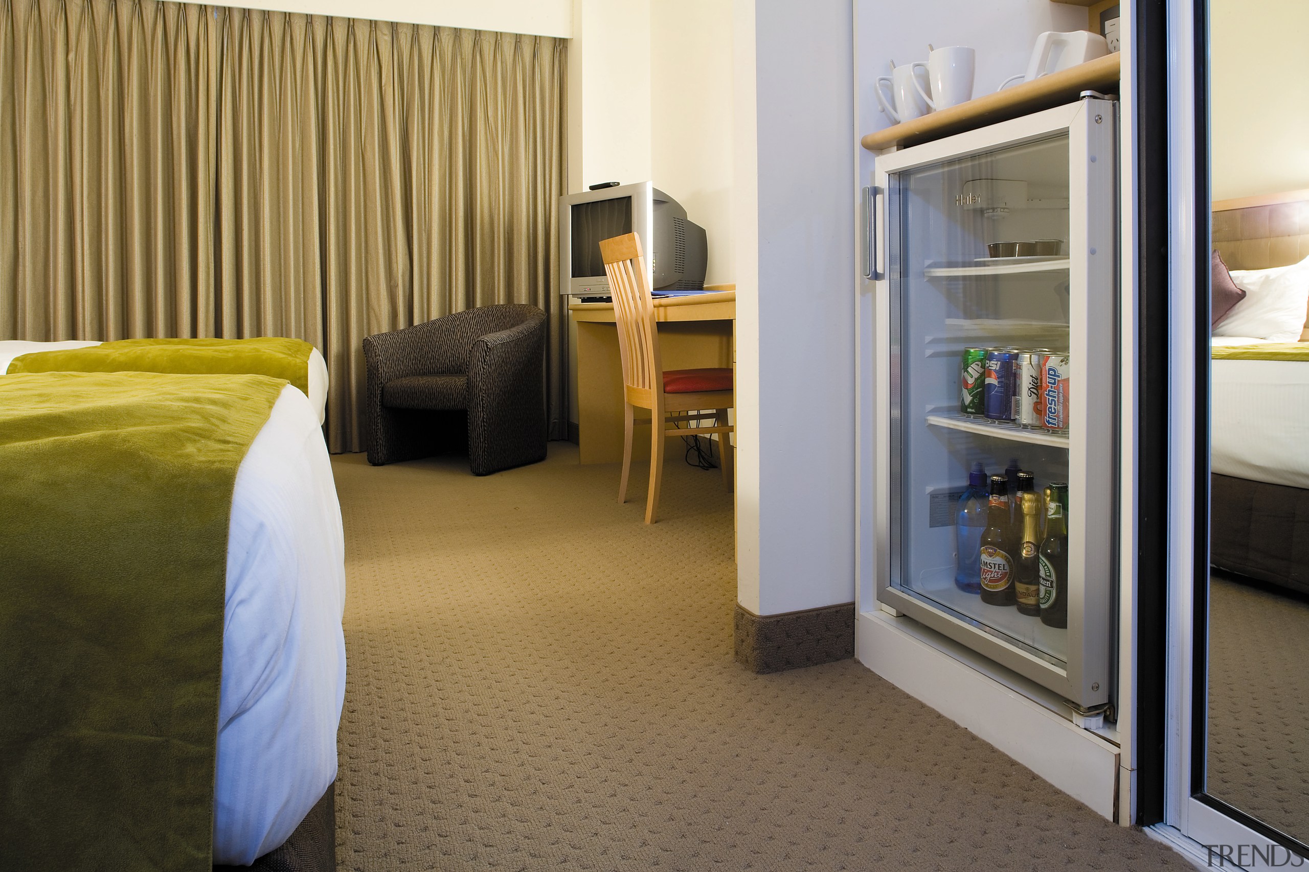 A view of a Haier mini fridge. - bedroom, floor, flooring, furniture, interior design, real estate, room, suite, brown