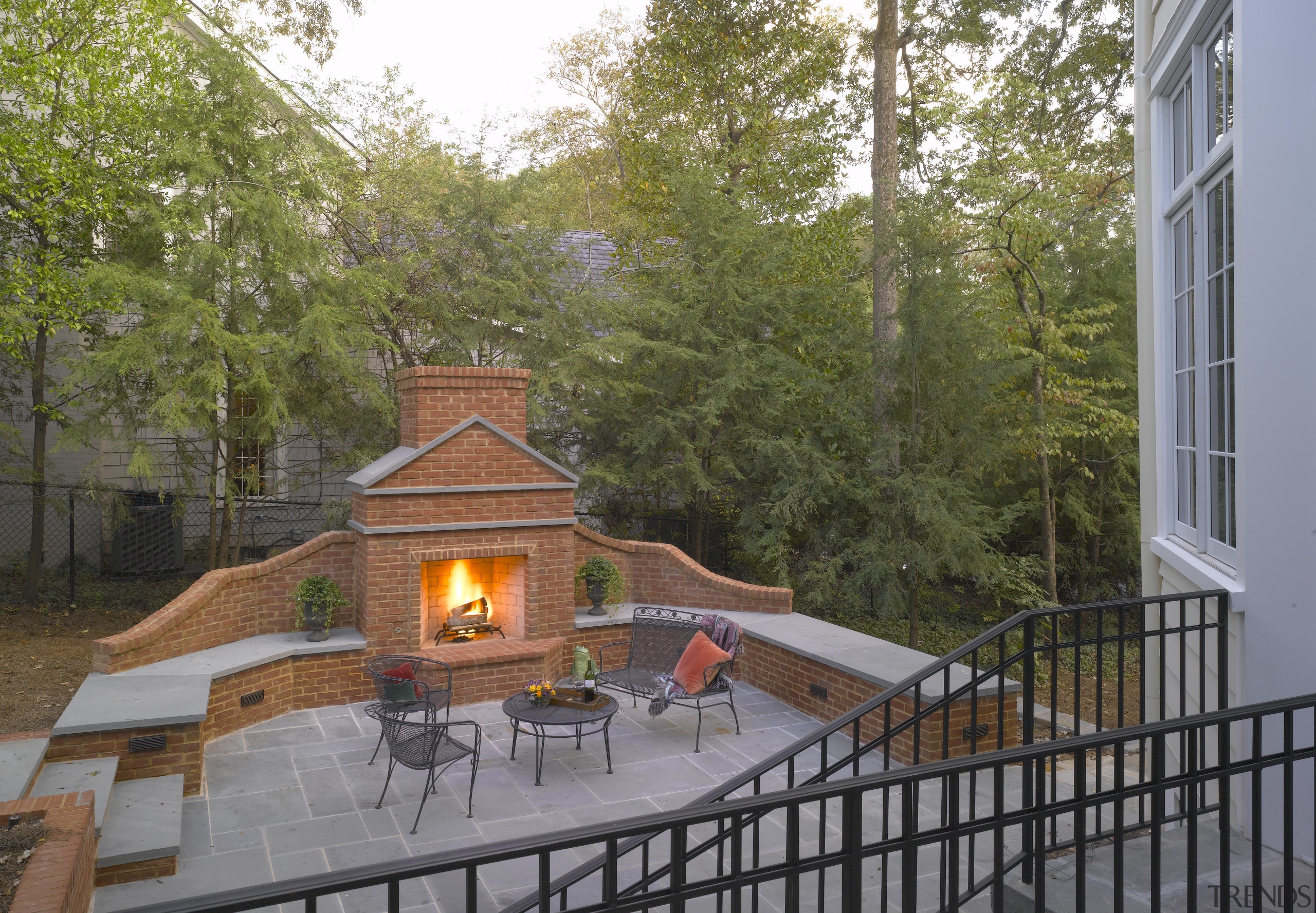 An exterior view of the patio area, pavers, home, house, outdoor structure, property, real estate, tree, brown, gray